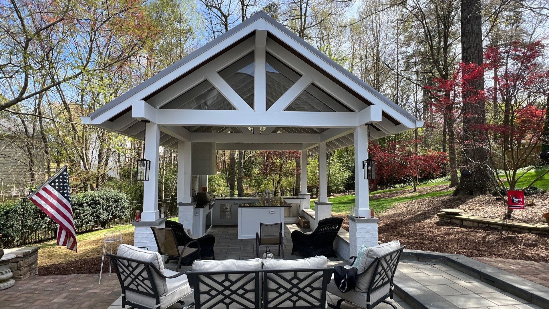 There is a gazebo with a lot of furniture underneath it