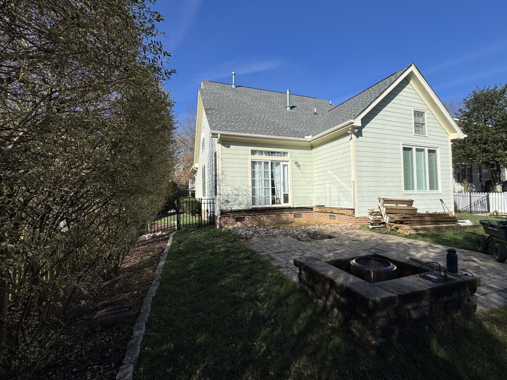 A white house with a fire pit in the backyard.