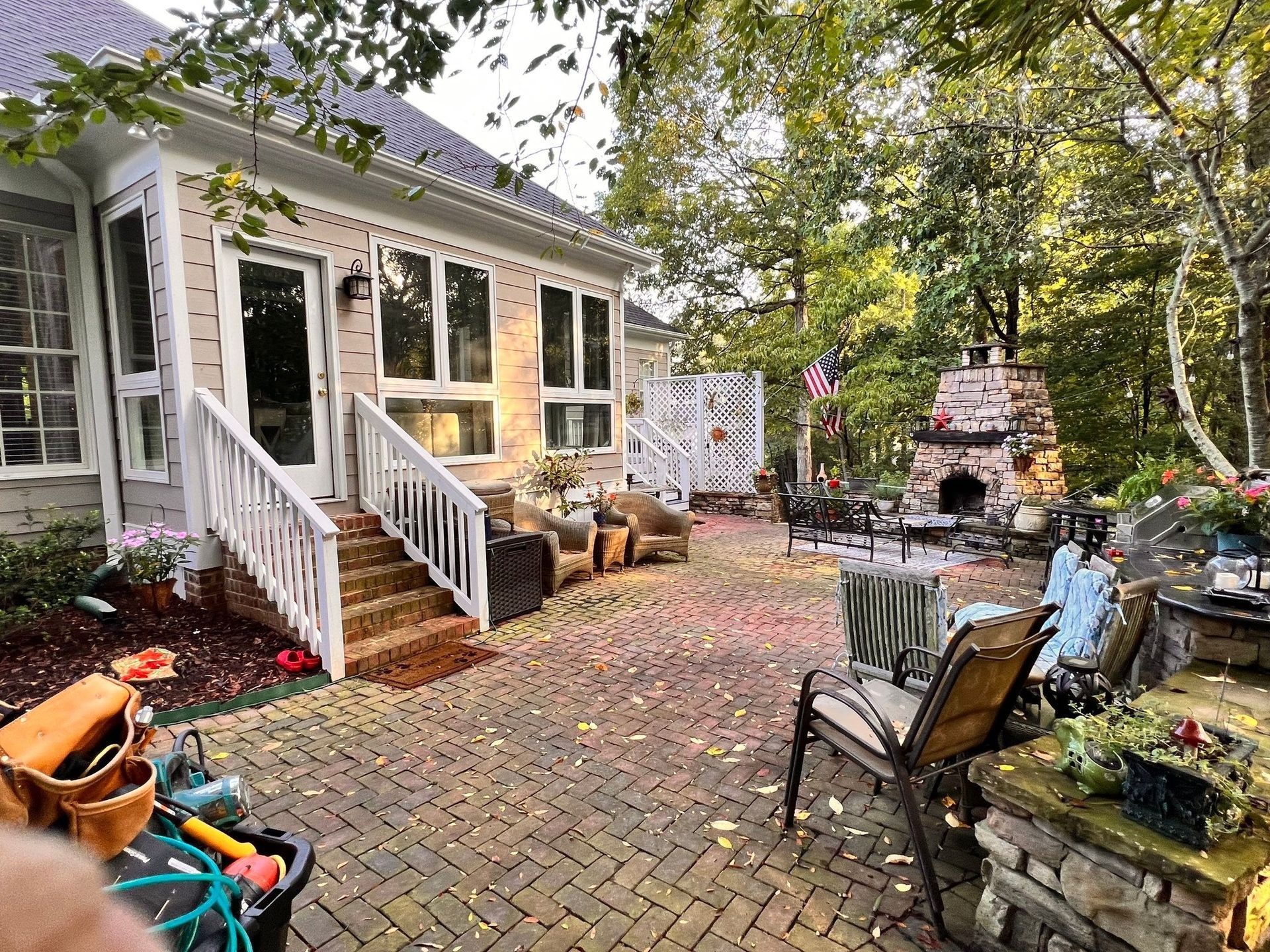 backyard patio with brick fireplace, seating, and sunroom