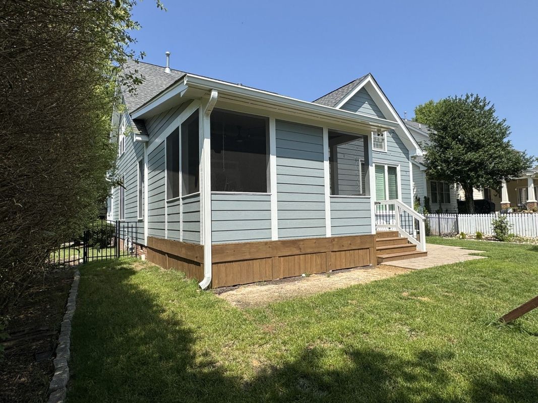 screened-in porch with blue siding, brown deck, and white trim