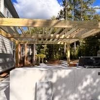 A wooden pergola is being built over a washing machine and dryer.