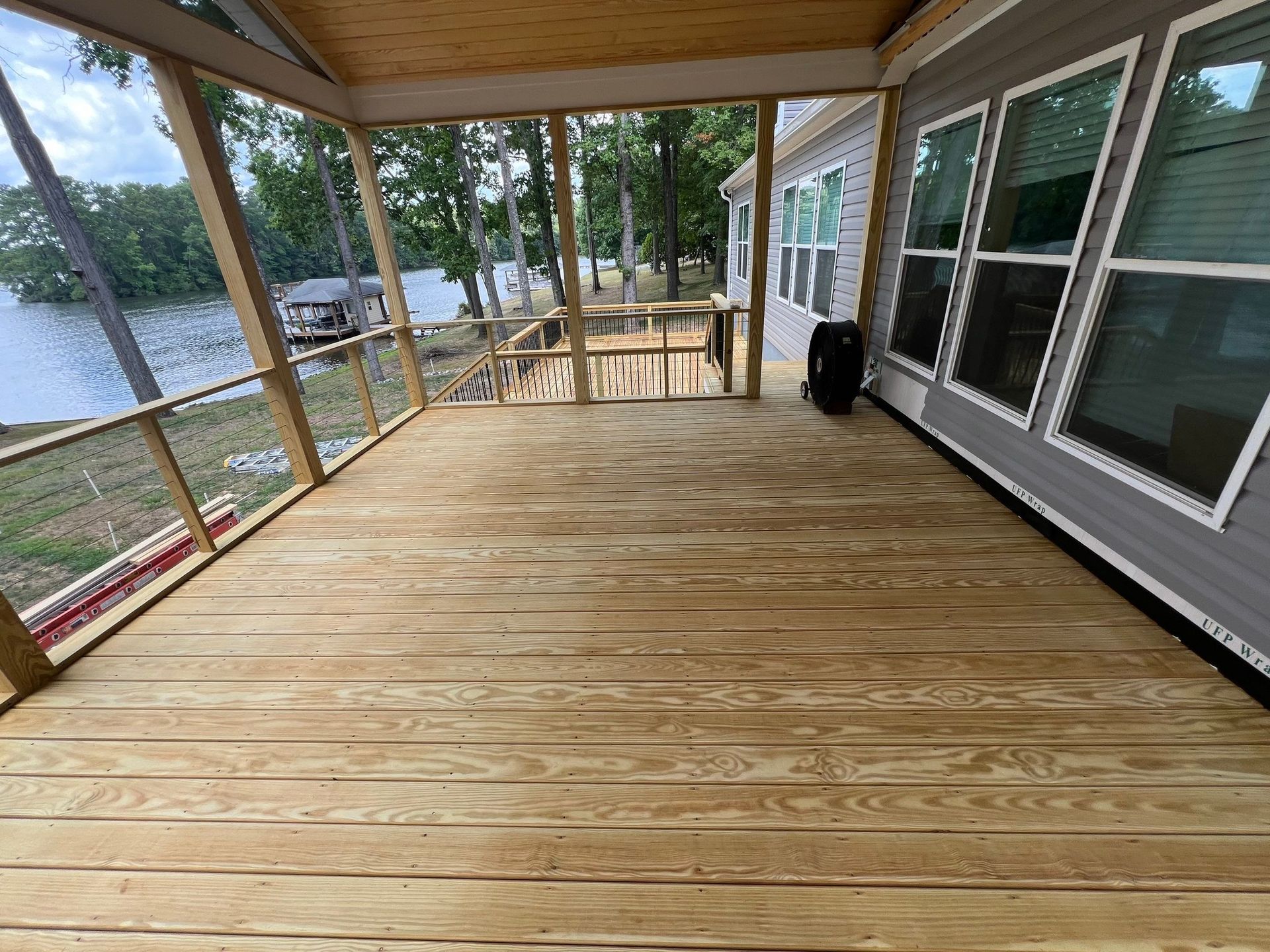 screened porch with wood floor overlooking a lake