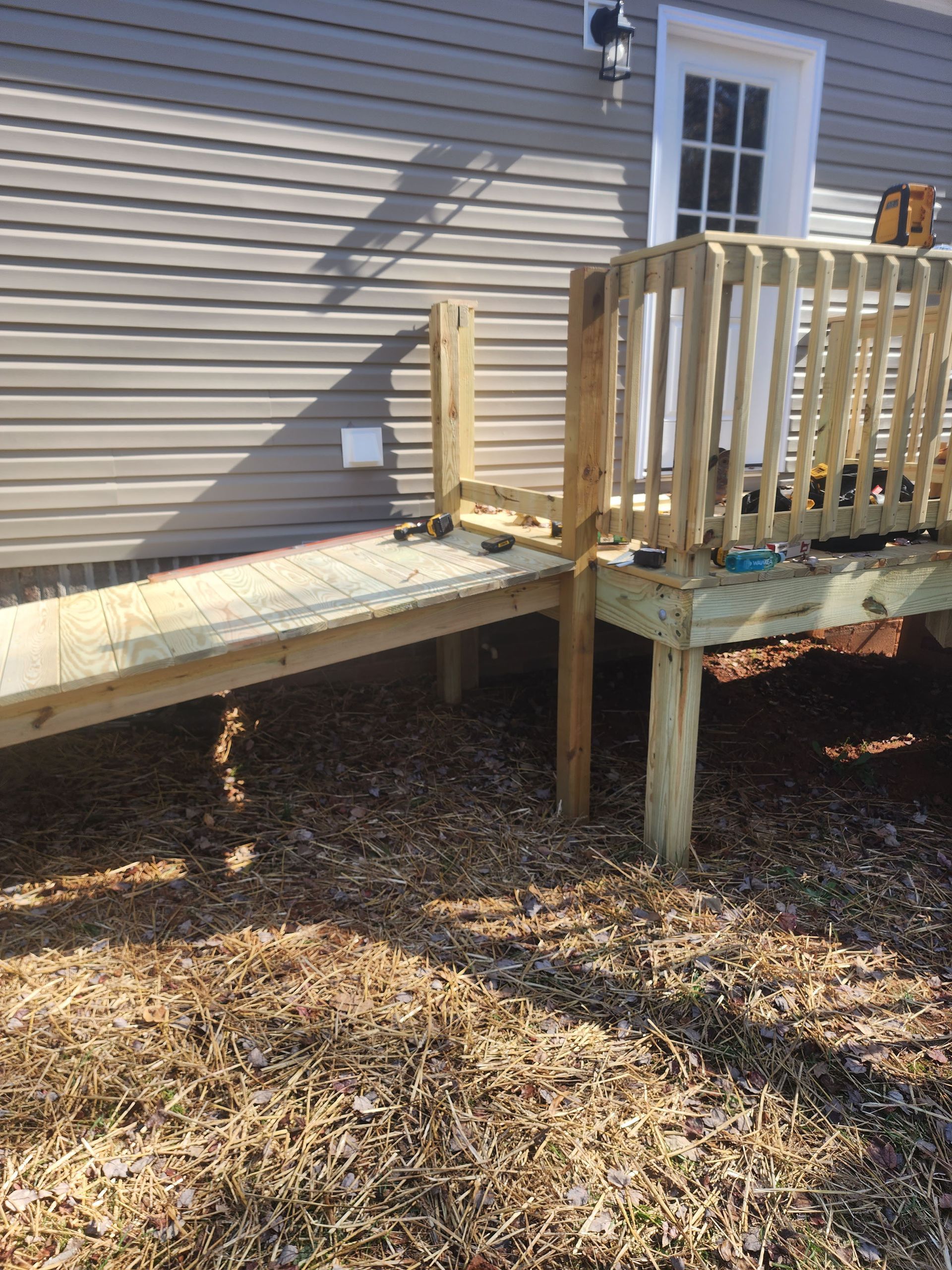 A wooden ramp is attached to the side of a house.