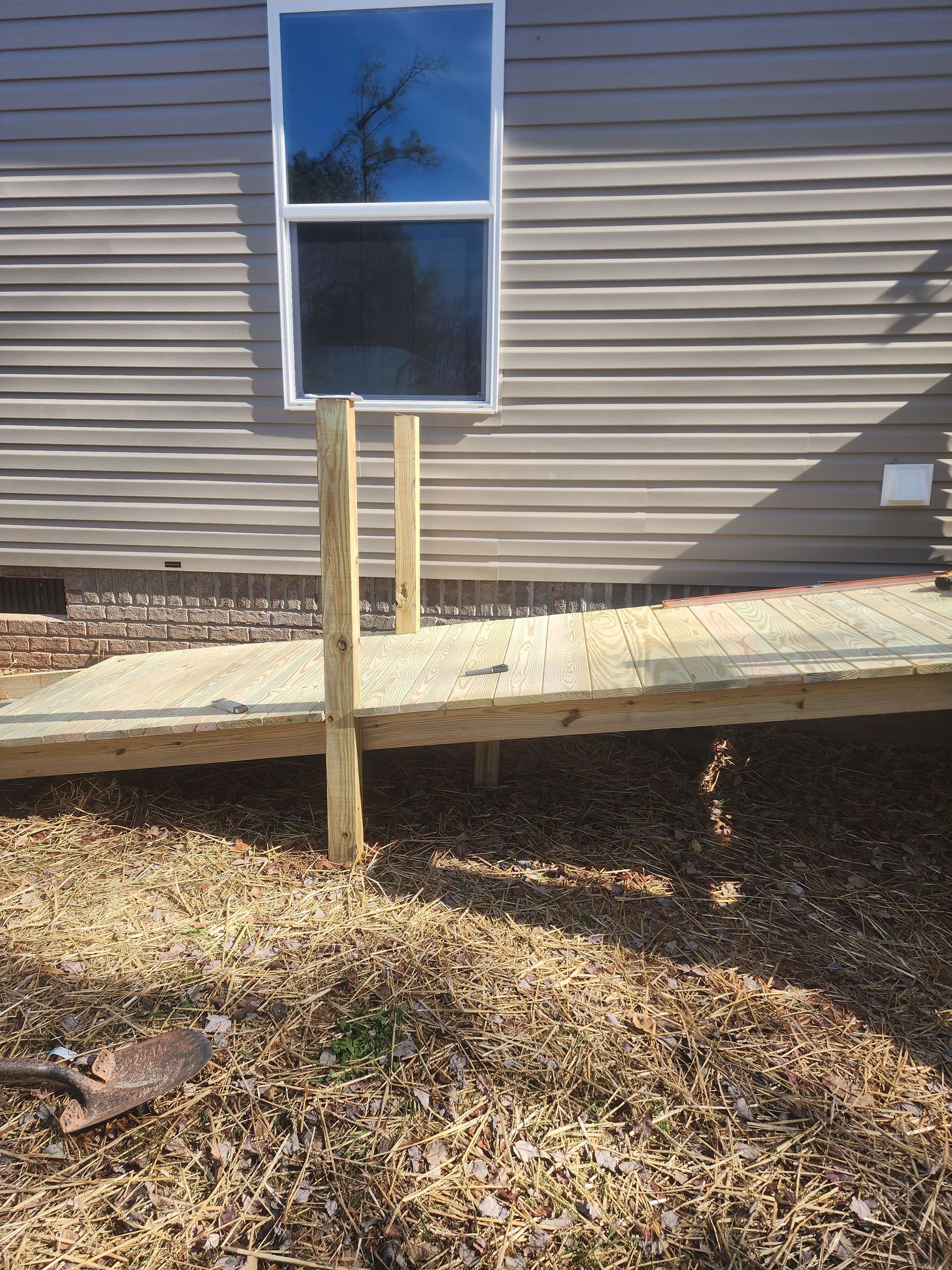 A wooden walkway is being built in front of a house.