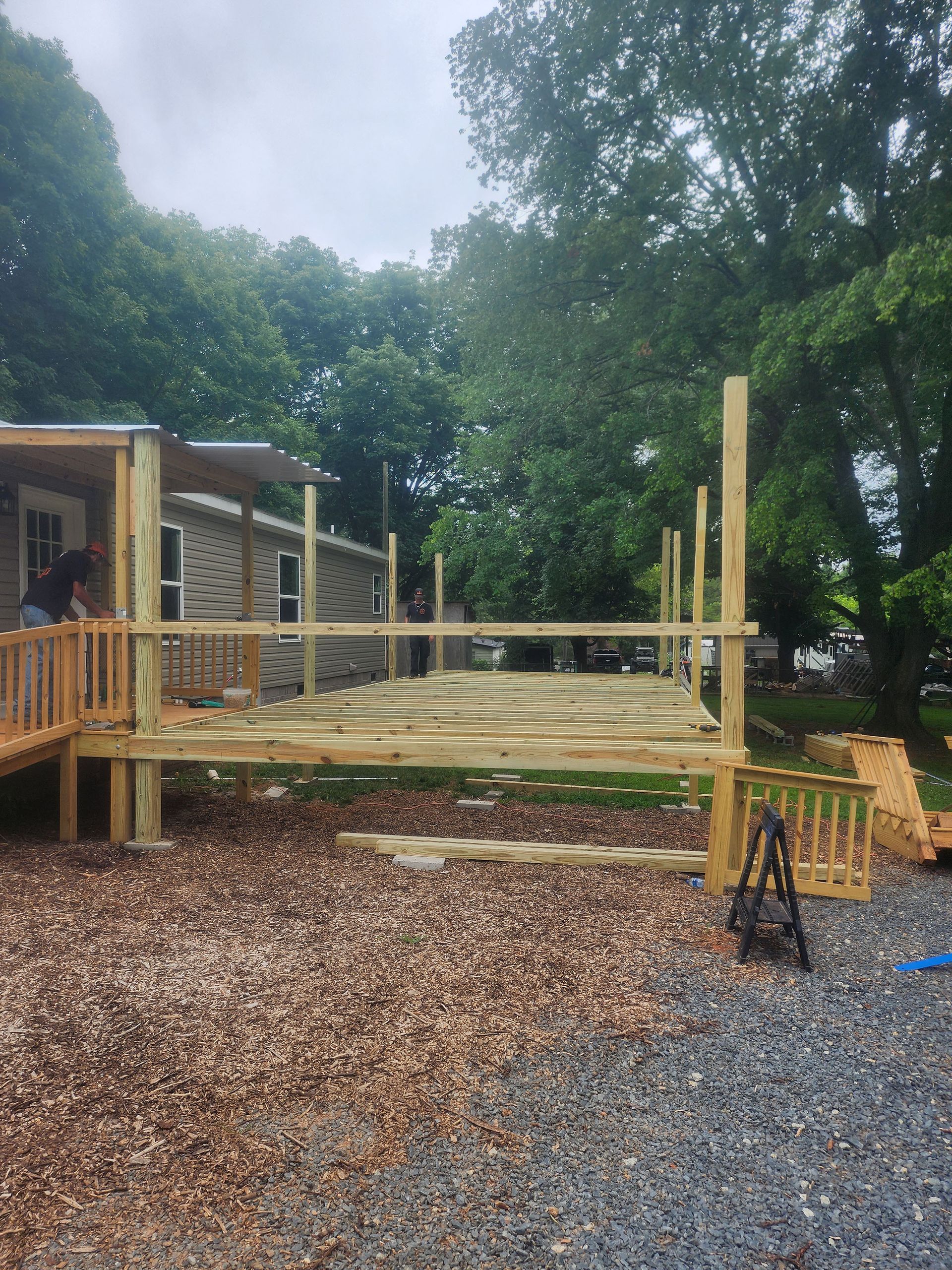 A wooden deck is being built in front of a house.