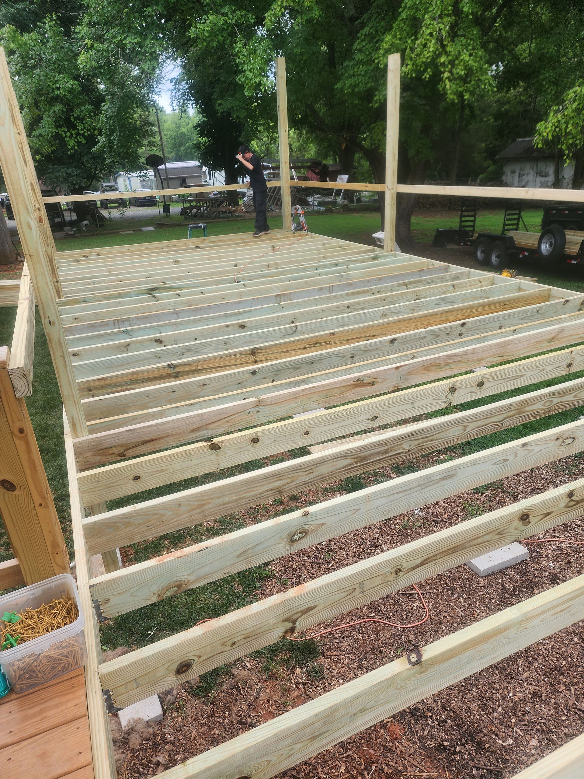 A wooden deck is being built in a yard.