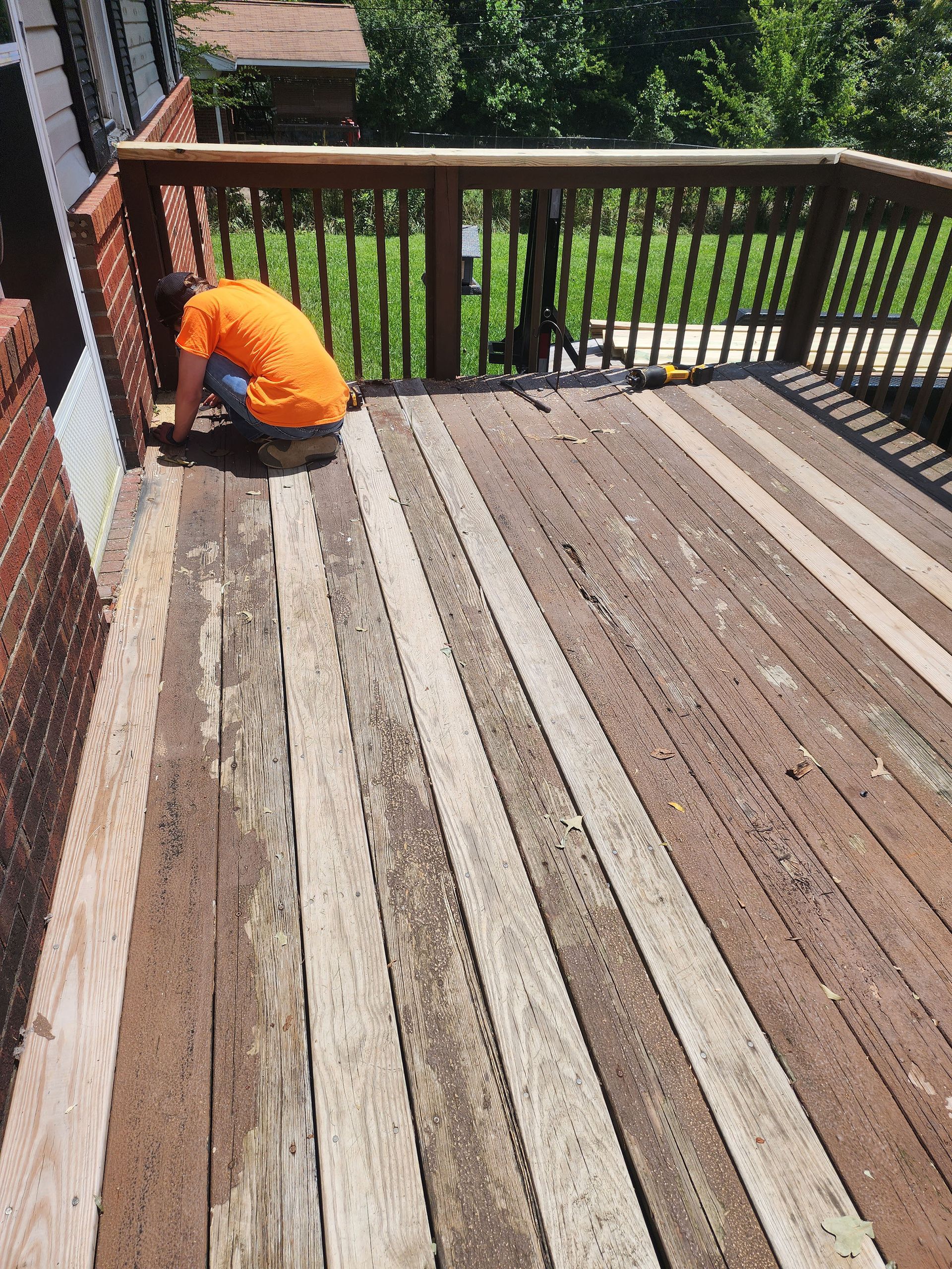 A man working on a wooden deck.