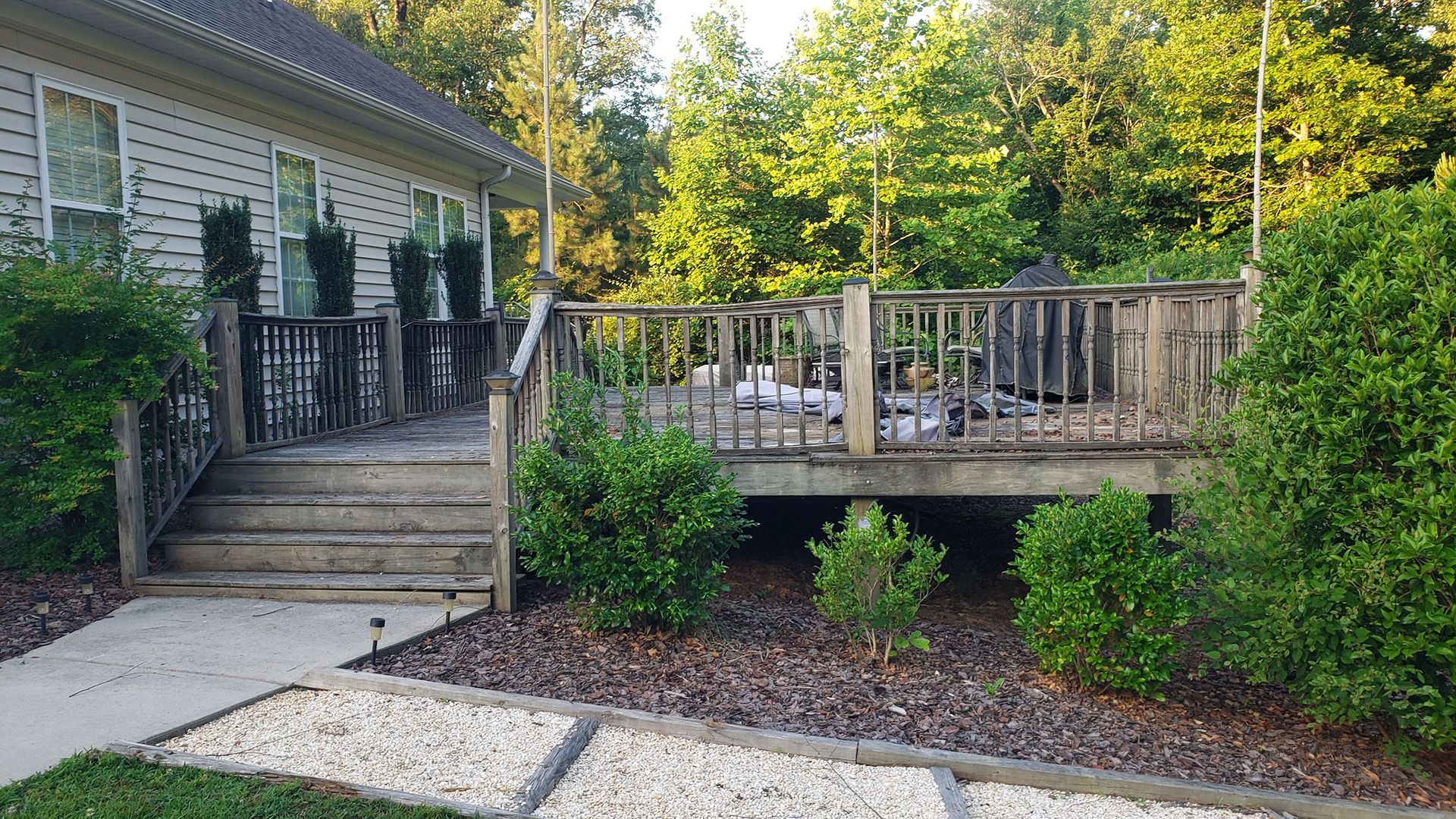 A house with a large deck and stairs in front of it.