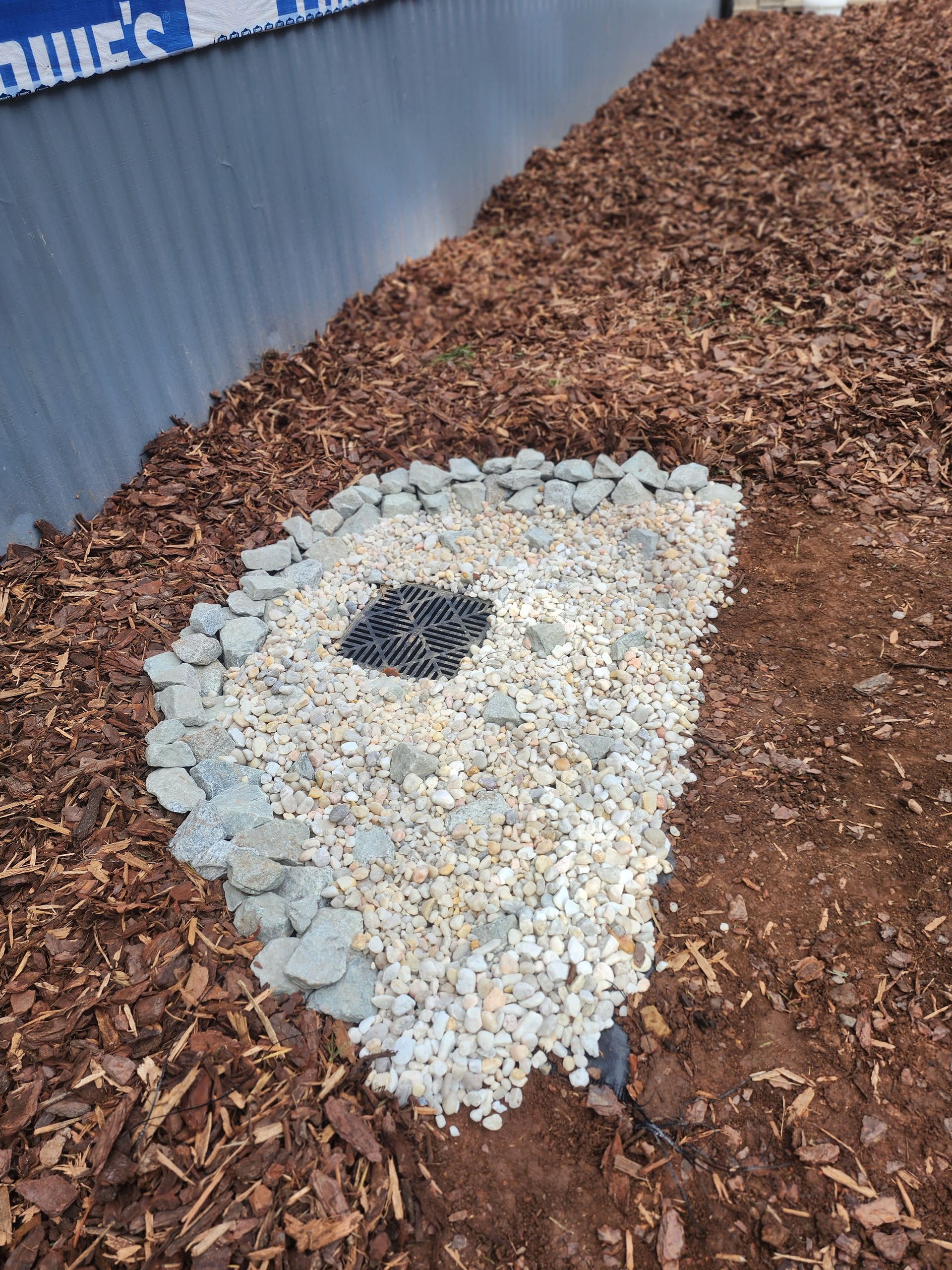 A pile of gravel is sitting on top of a pile of mulch.
