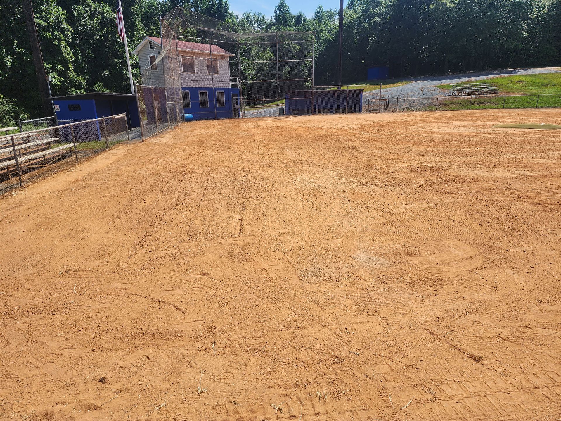 A field with a fence and a house in the background.
