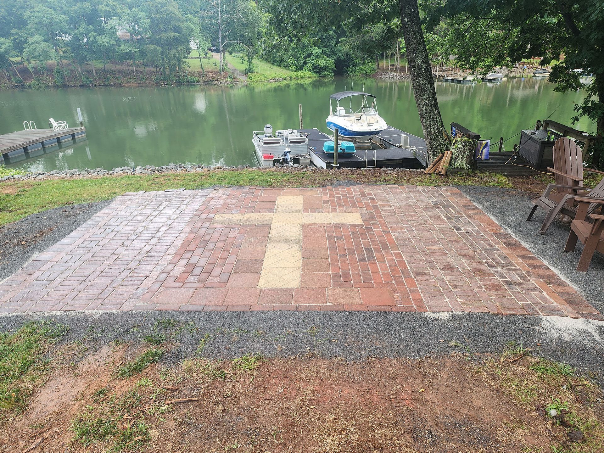 A brick patio with a boat in the background