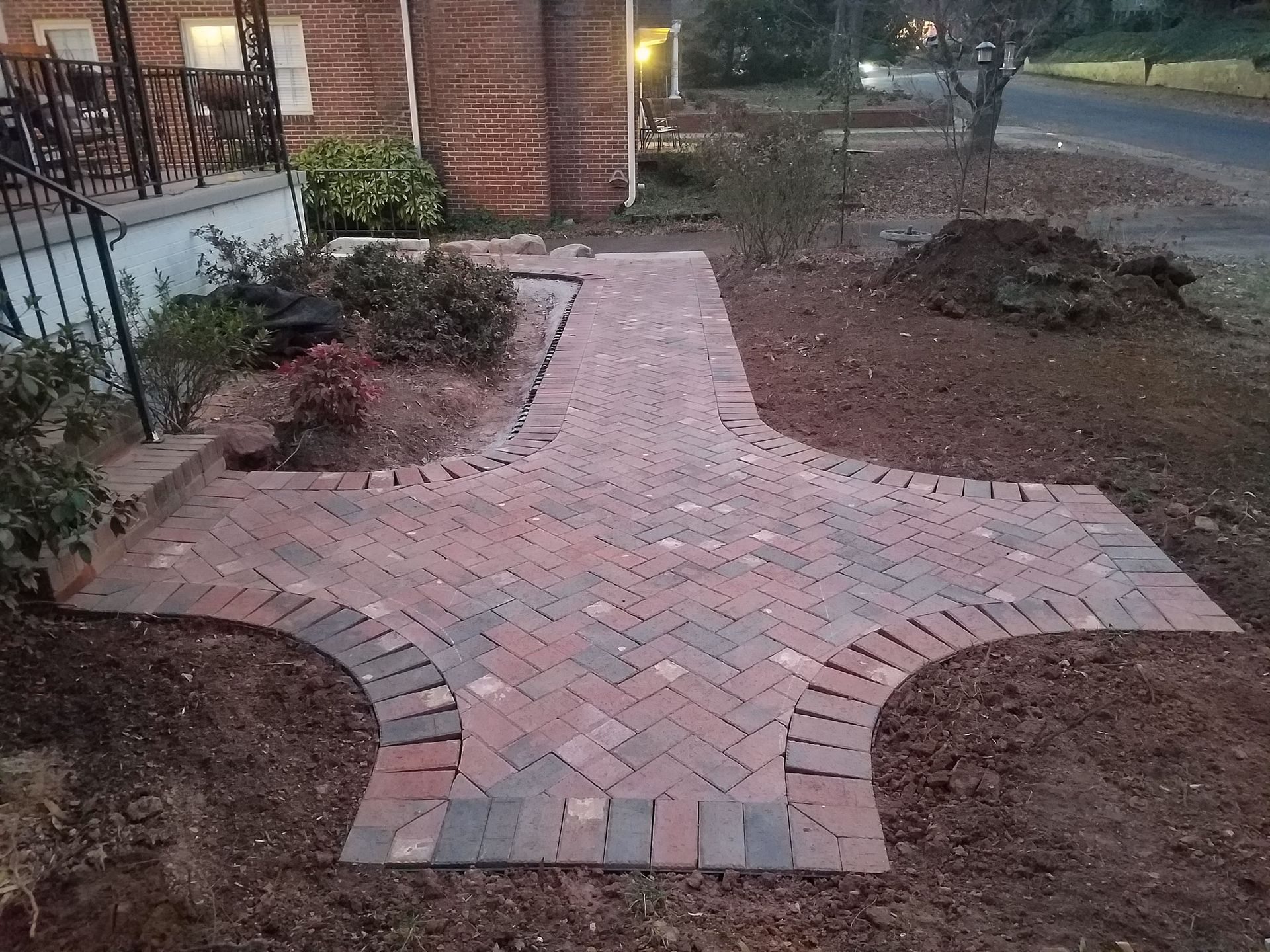 A brick walkway is being built in front of a house.