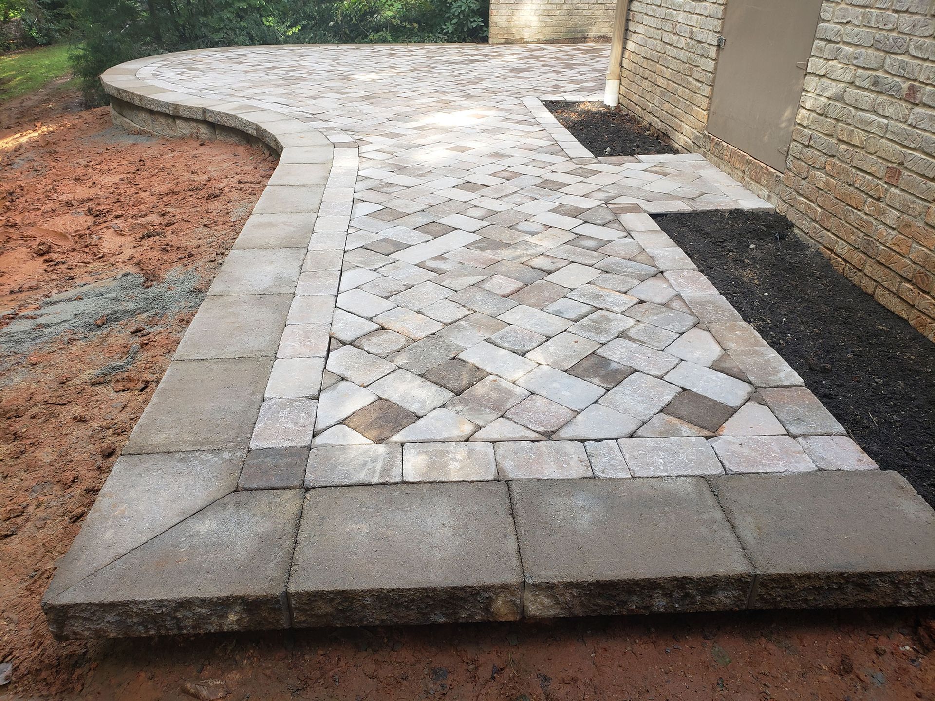 A brick walkway is being built in front of a brick building
