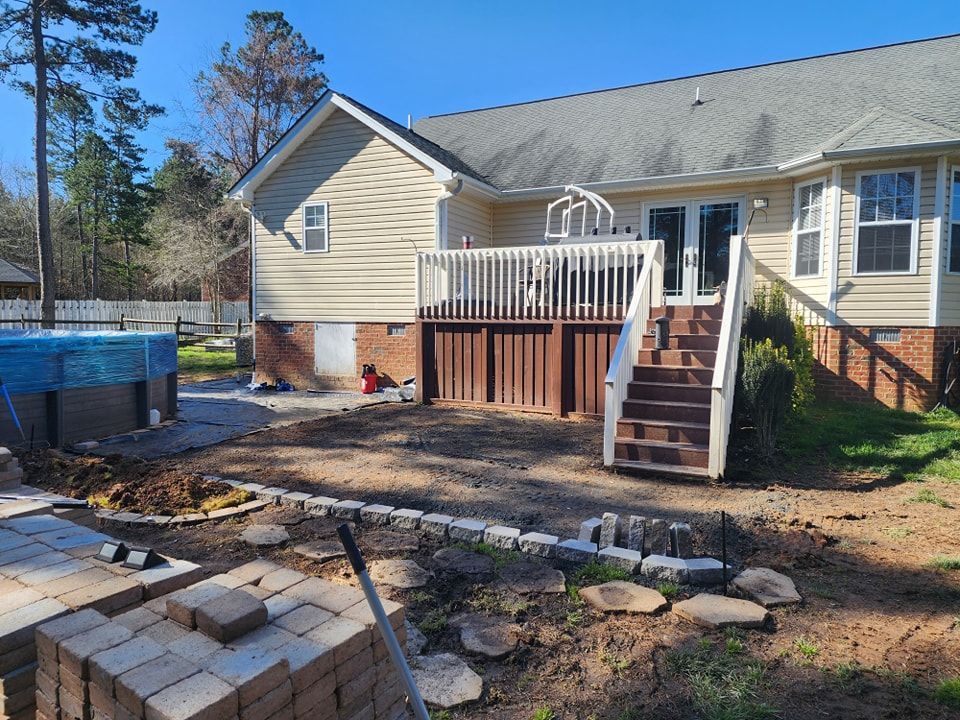 A house with a large deck and stairs in the backyard.