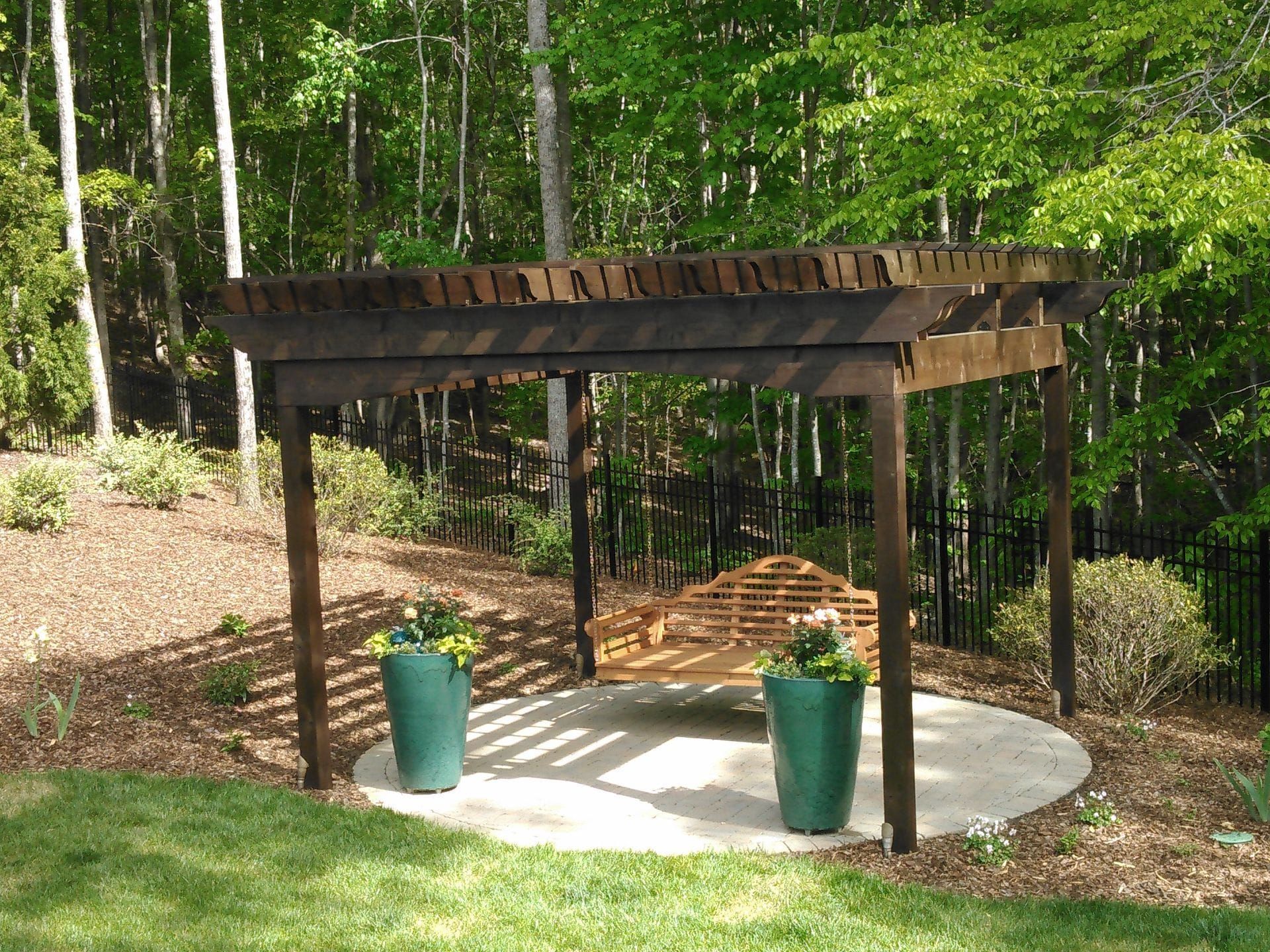 A wooden pergola with a bench underneath it