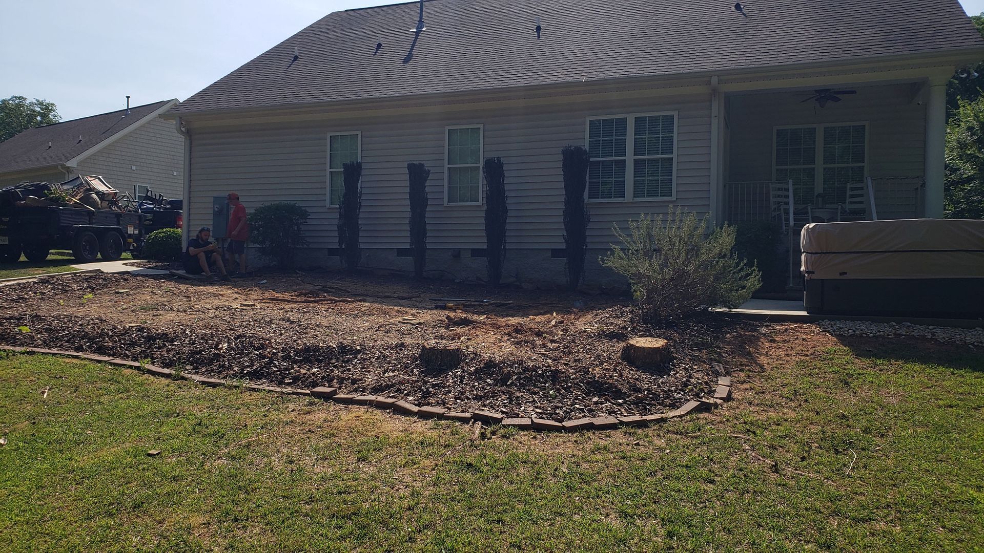 A house with a lot of stump in front of it.