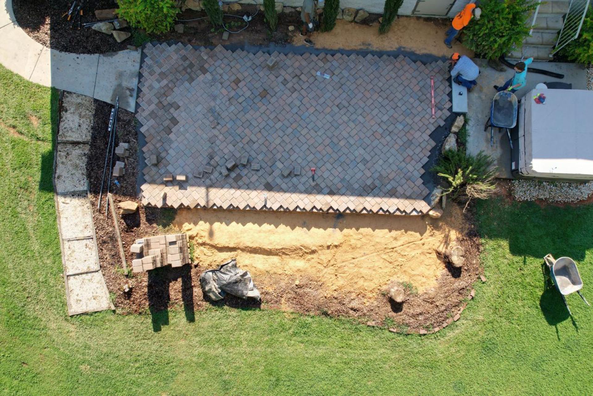 An aerial view of a patio being built in a backyard.