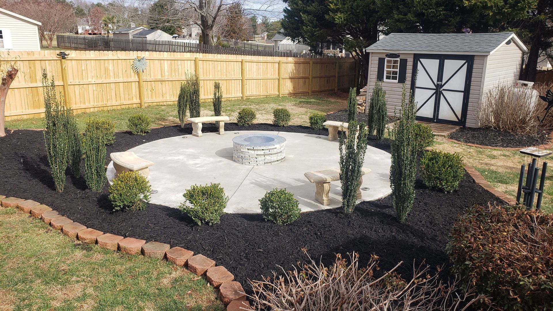 There is a fire pit in the middle of the backyard.