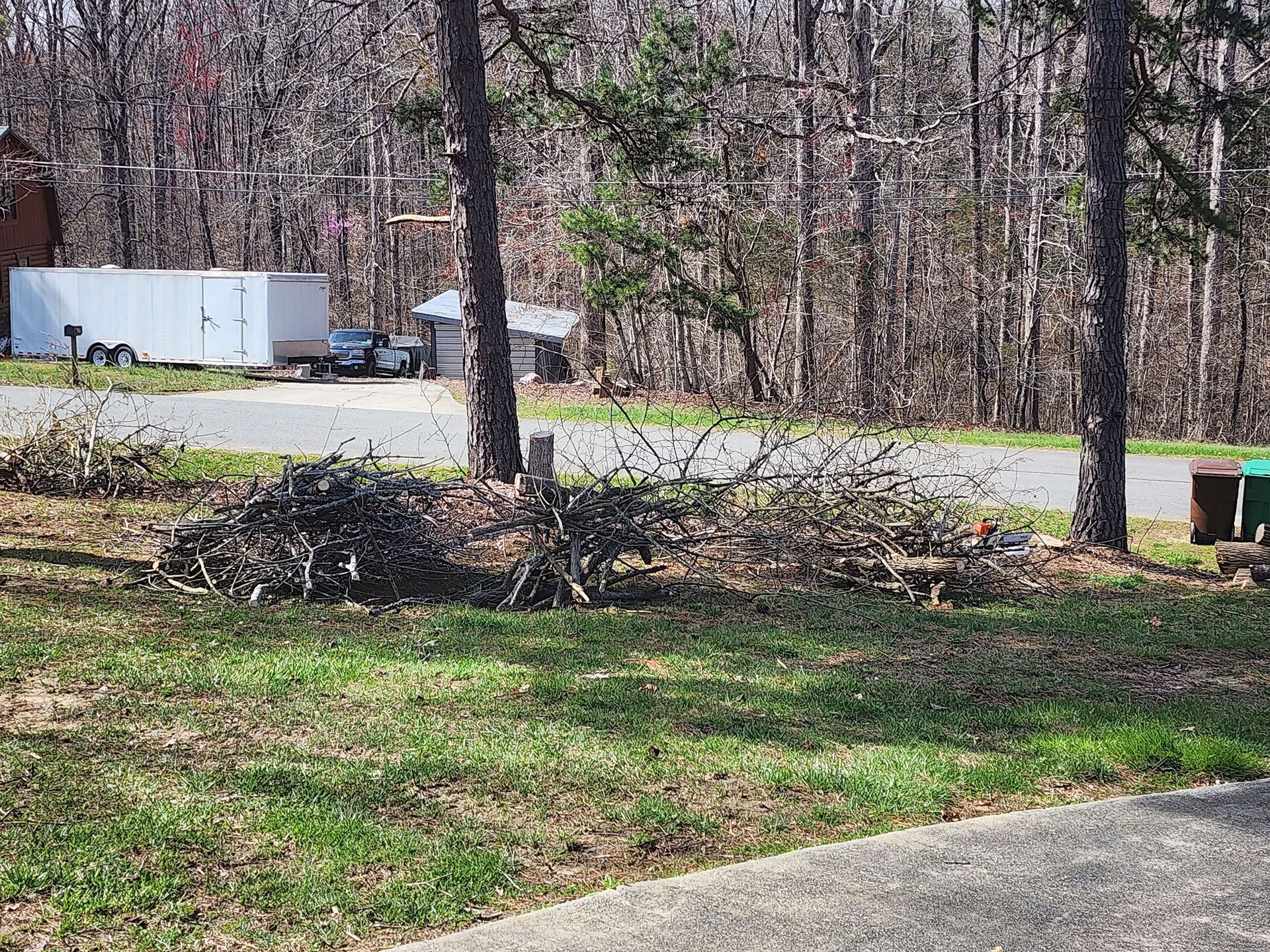 A white trailer is parked on the side of the road in the woods.