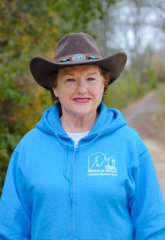 A woman wearing a cowboy hat and a blue hoodie.