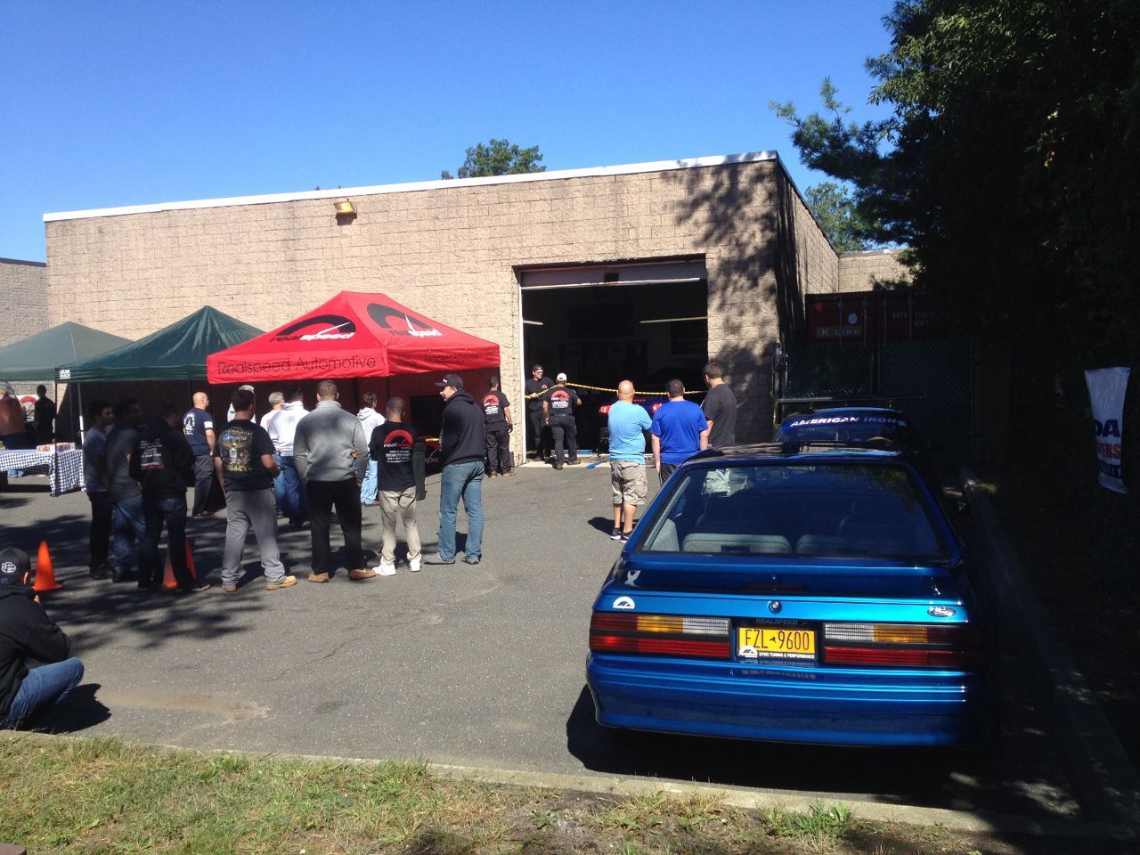 A blue car is parked in front of a building
