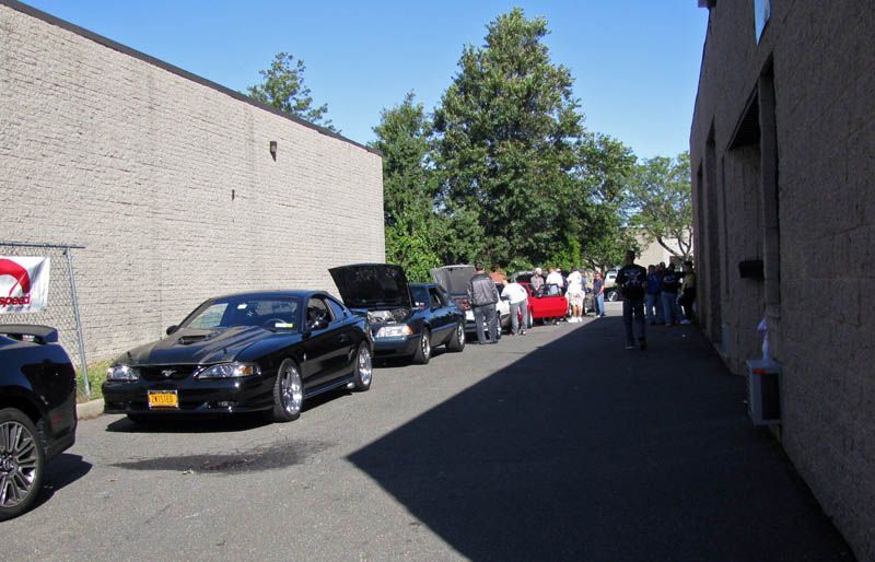 A row of cars are parked on the side of the road