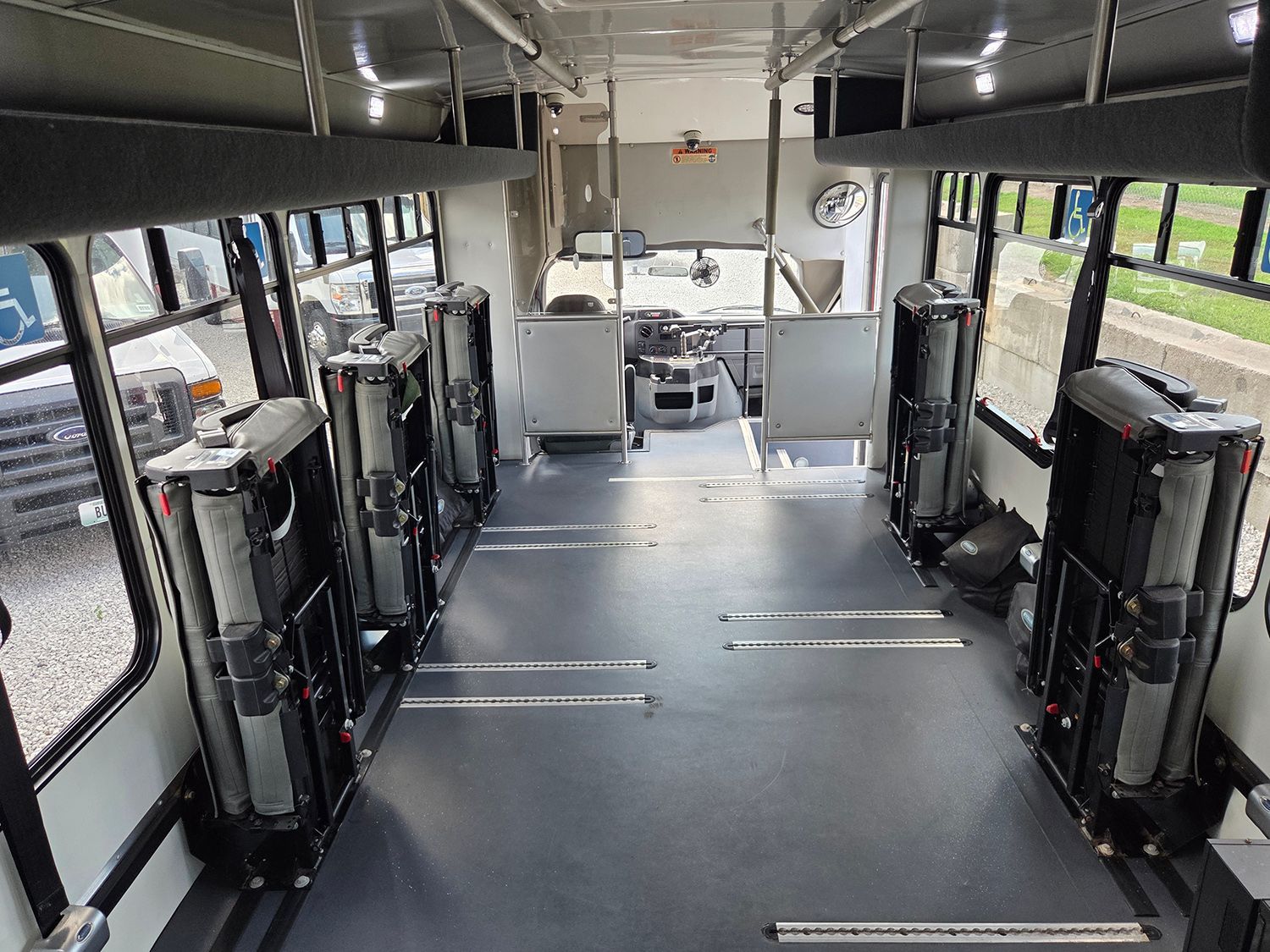 Empty bus interior with folded wheelchair seats and large windows on both sides