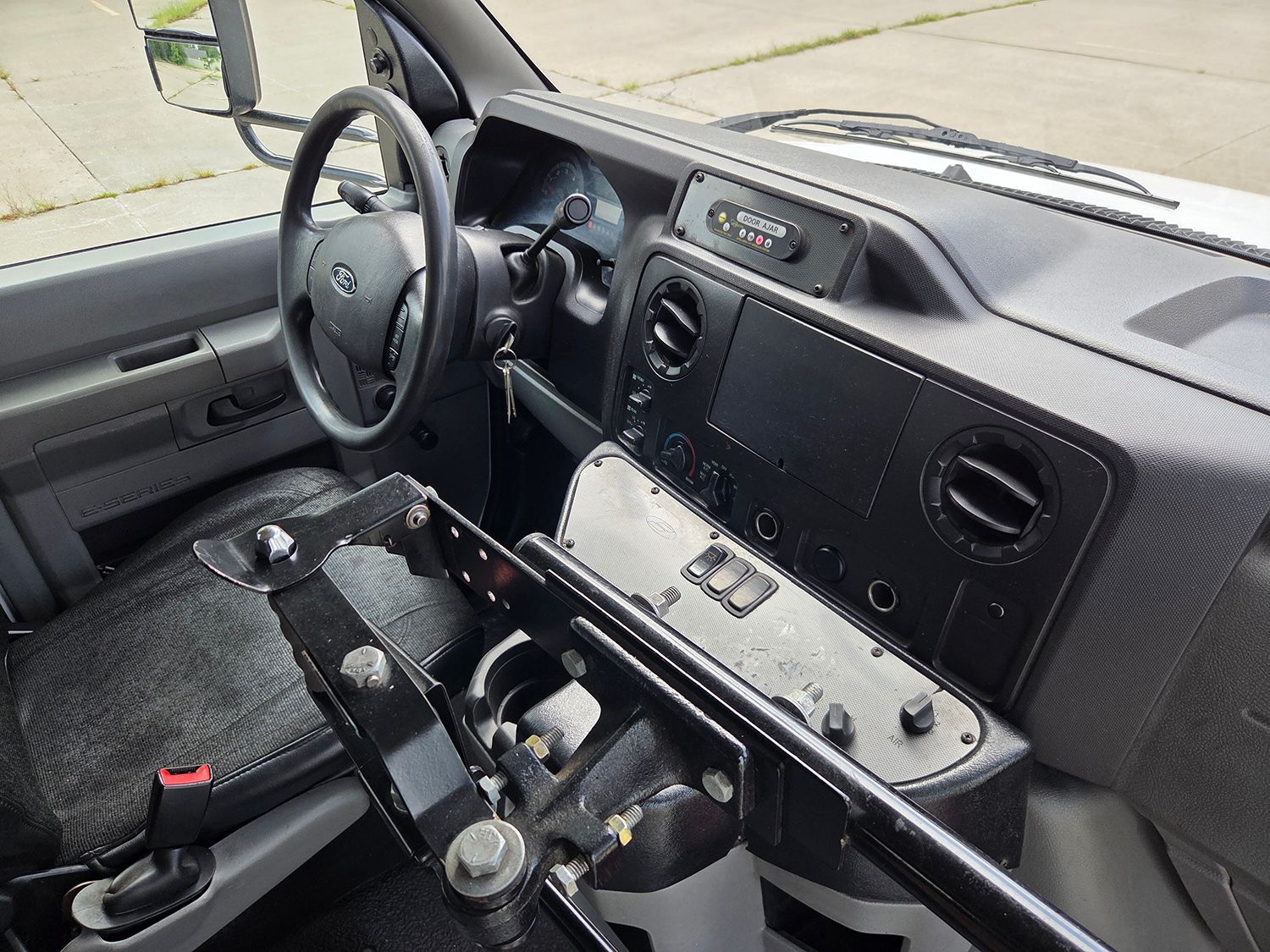 Interior of a rugged off-road vehicle with a steering wheel, gauges, and a mounted control panel.