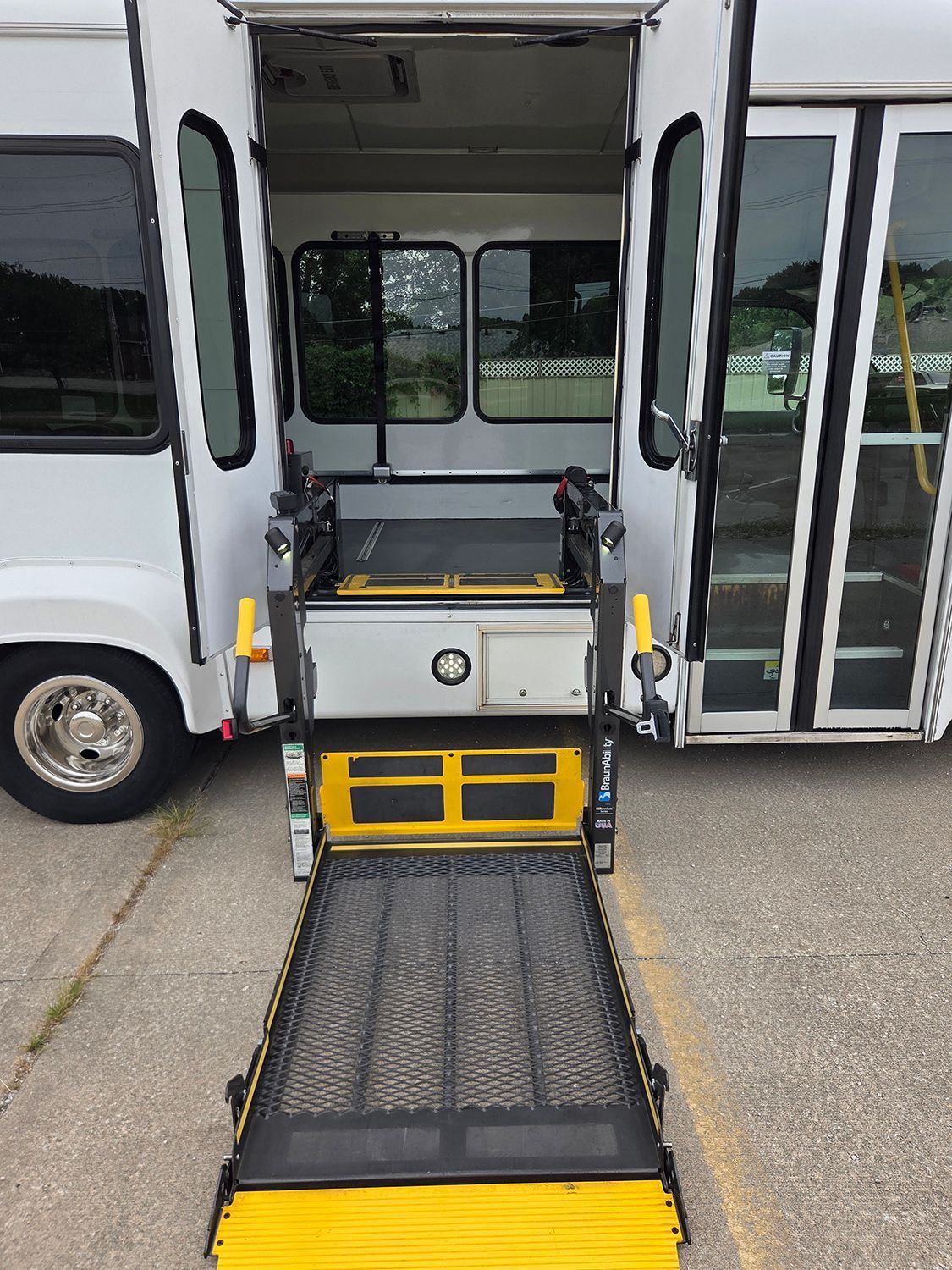 Accessible bus with wheelchair ramp extended at the open entrance.
