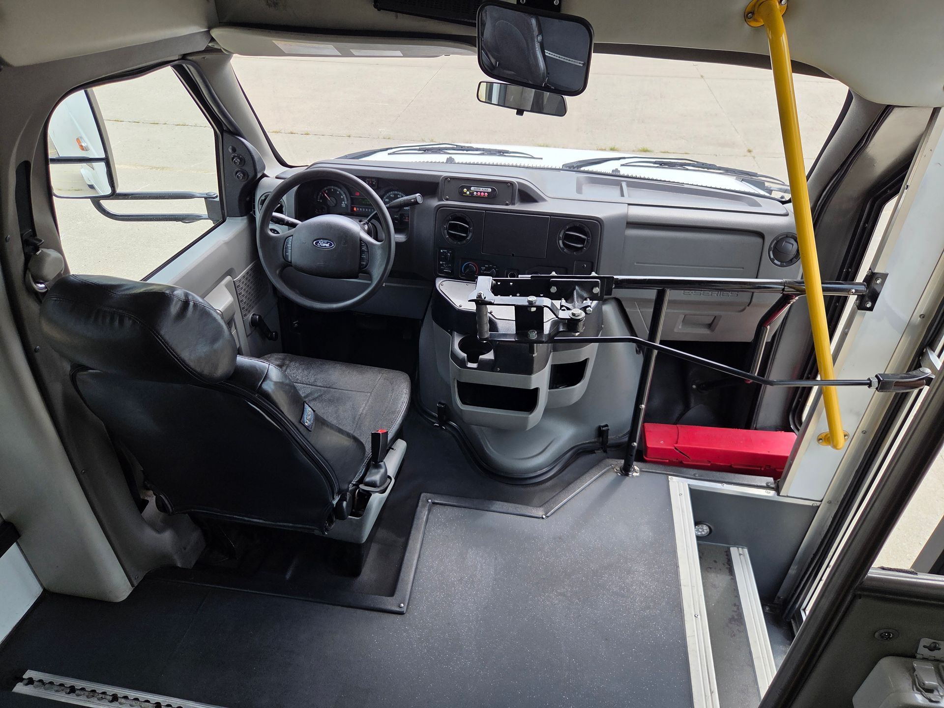 Inside of a vehicle adapted for wheelchair access, with a swivel driver’s seat and open floor space.