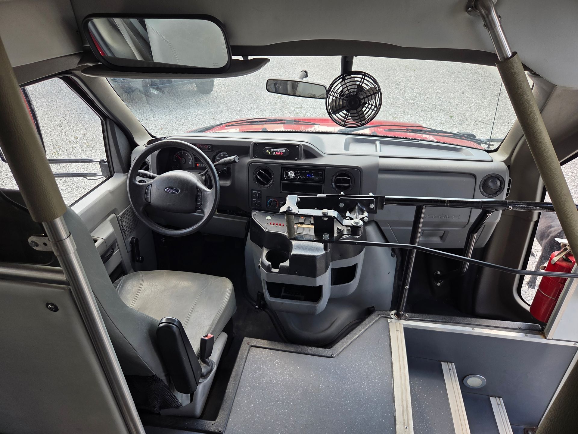 Car interior stripped for racing, with roll cage, racing seat, dashboard, and exposed floor.
