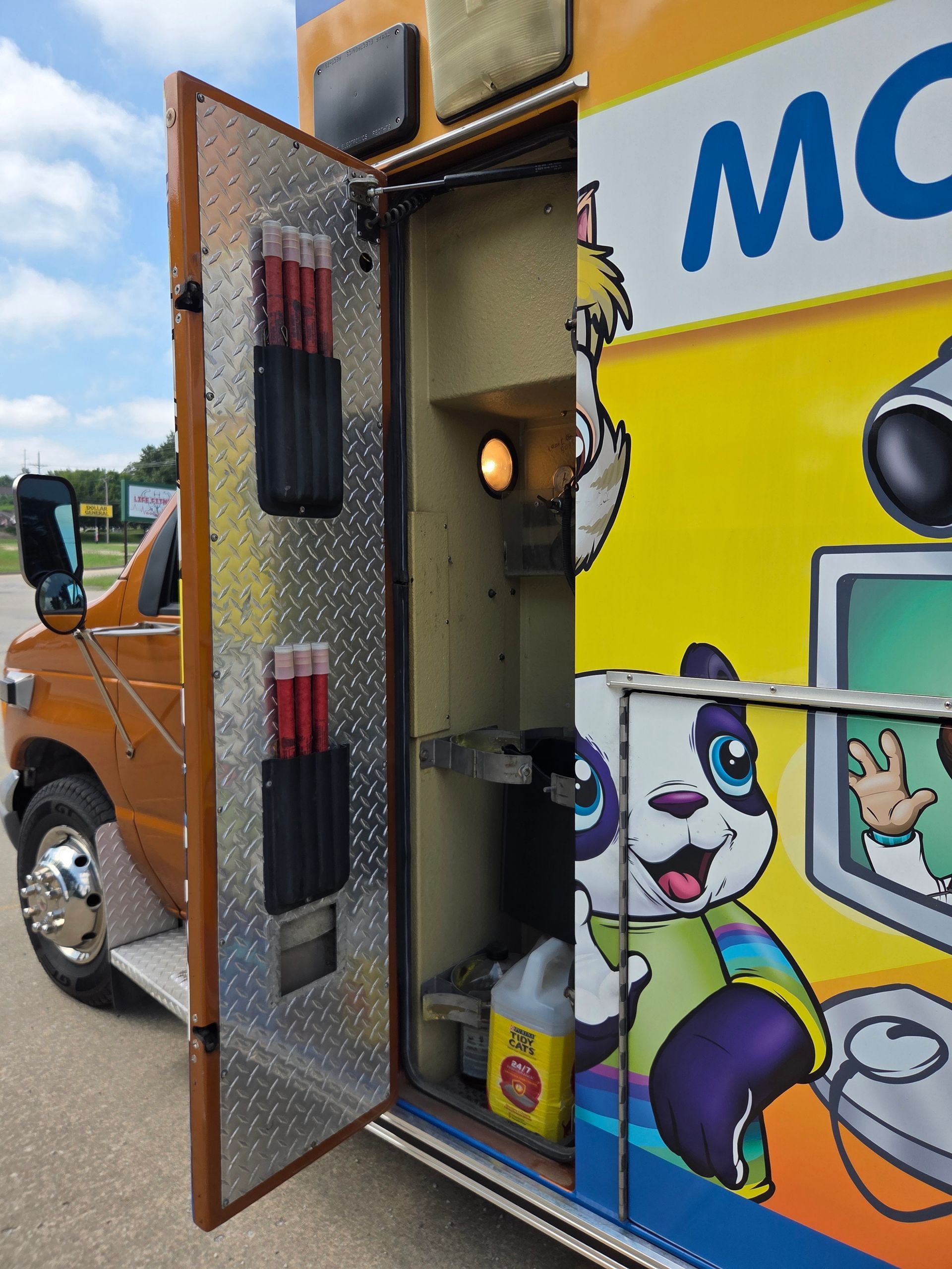 Open truck side door showing a colorful cartoon mural and storage shelves inside