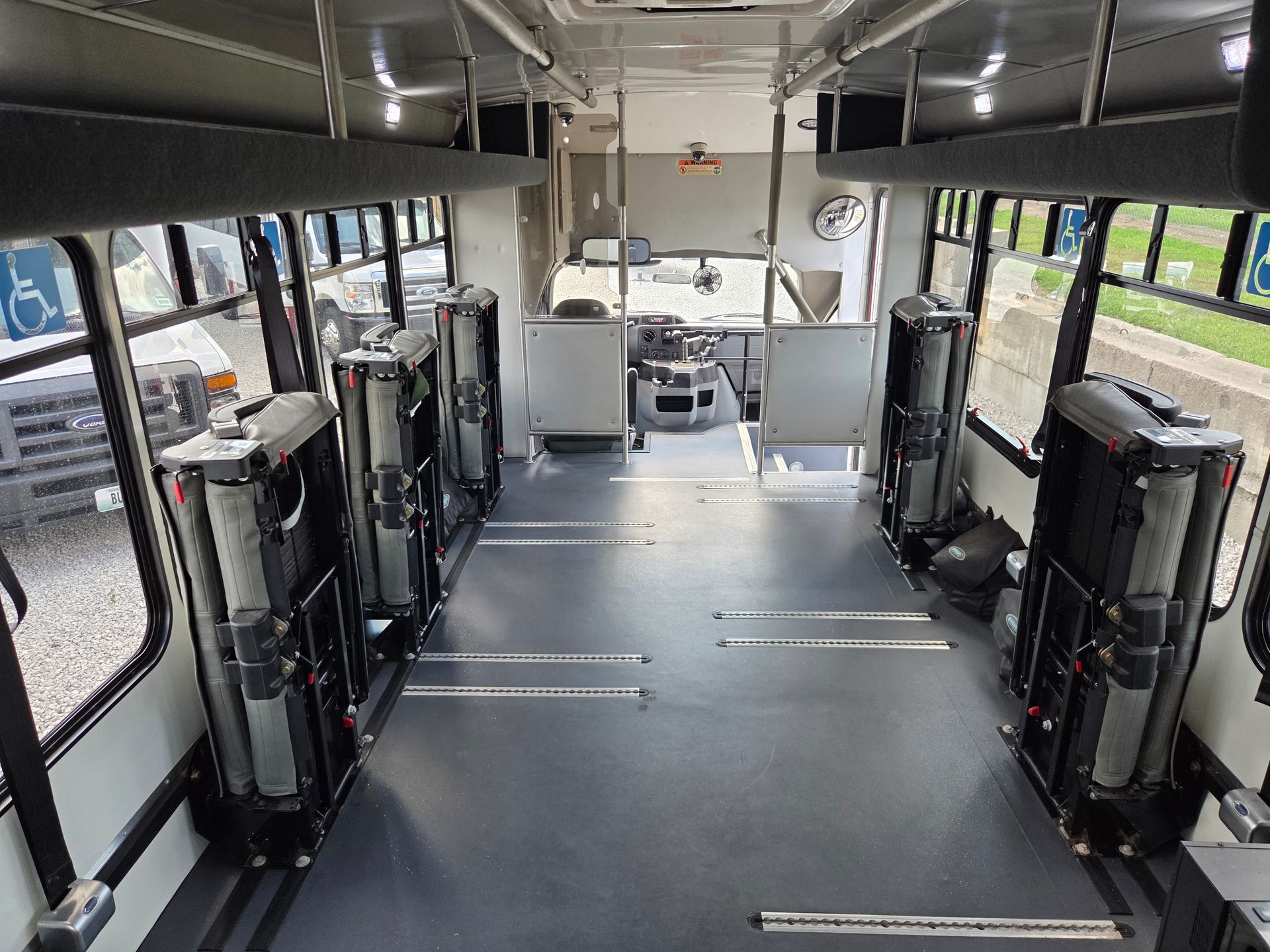Empty bus interior with folded seats, aisle, and front driver’s area