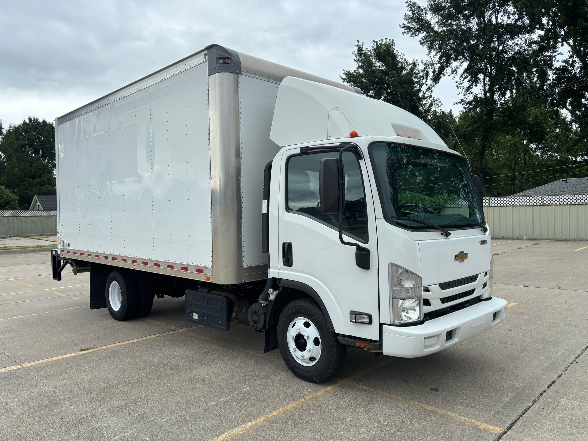 White box truck parked on a lot, viewed from the front-left side
