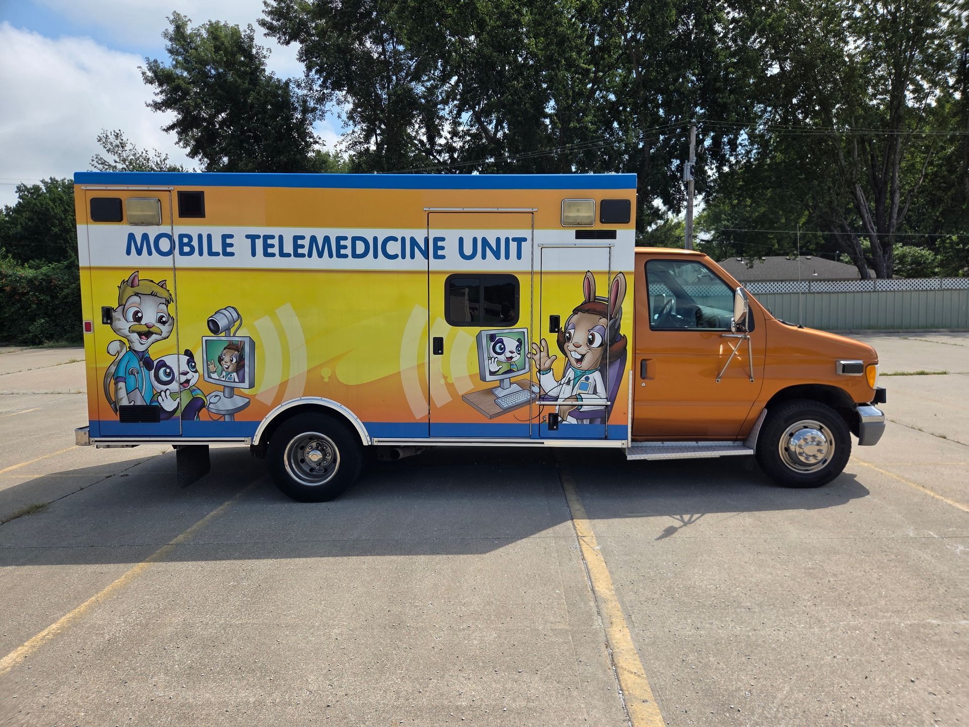 Orange mobile telemedicine unit parked in a lot, with cartoon medical graphics on the side.