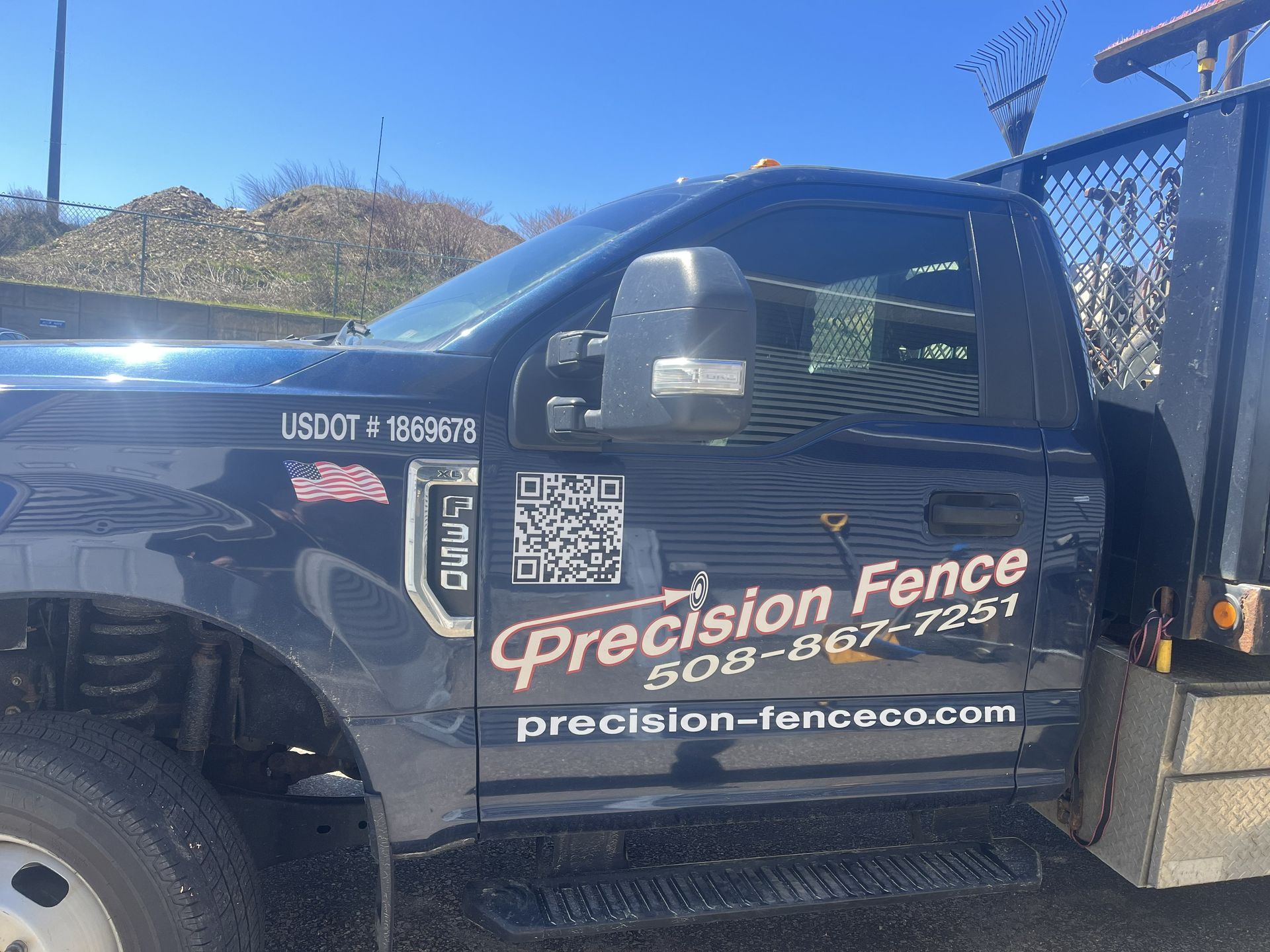 Blue Precision Fence truck with company logo, phone number, and website parked outdoors.