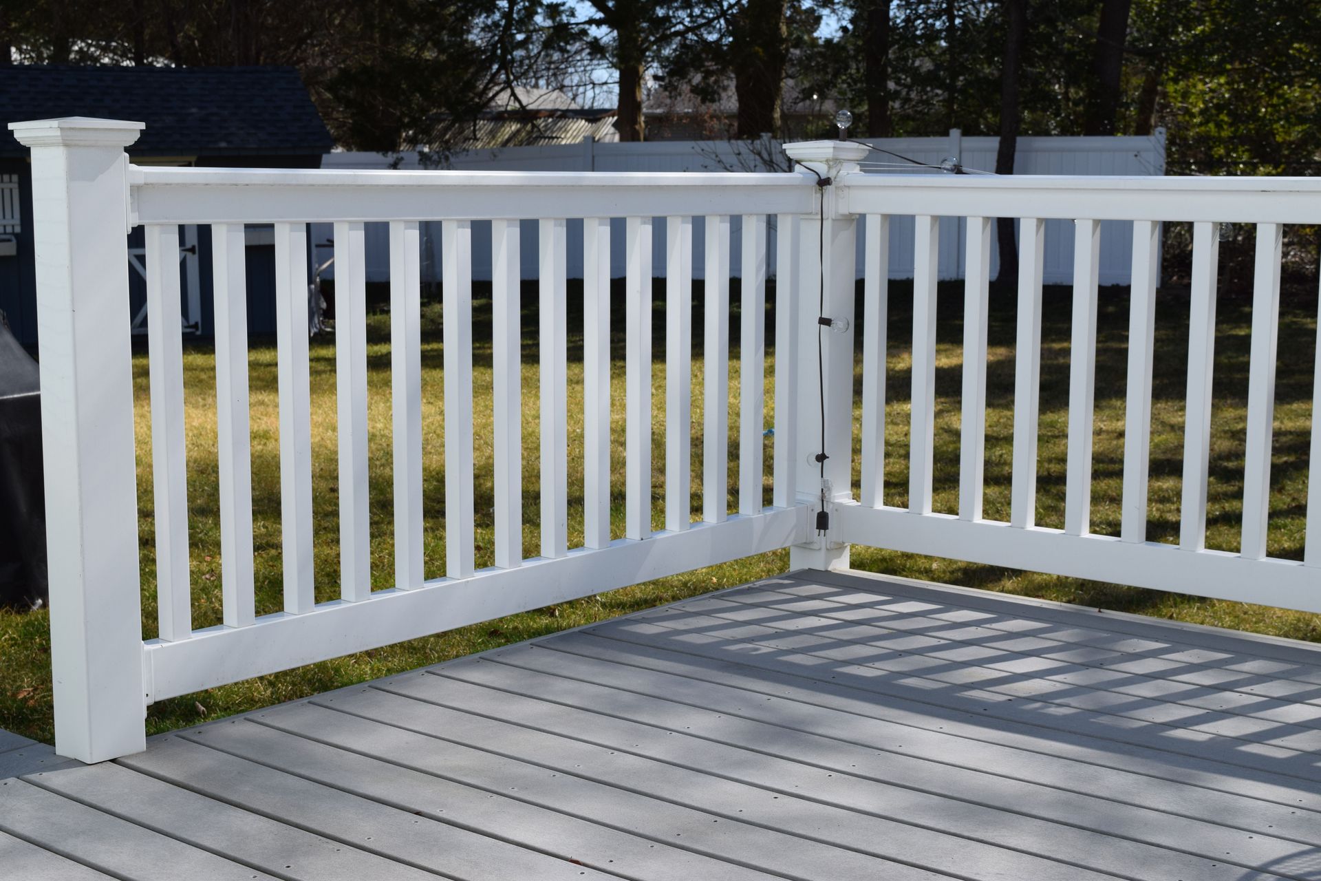 White deck railing with gray composite deck flooring.