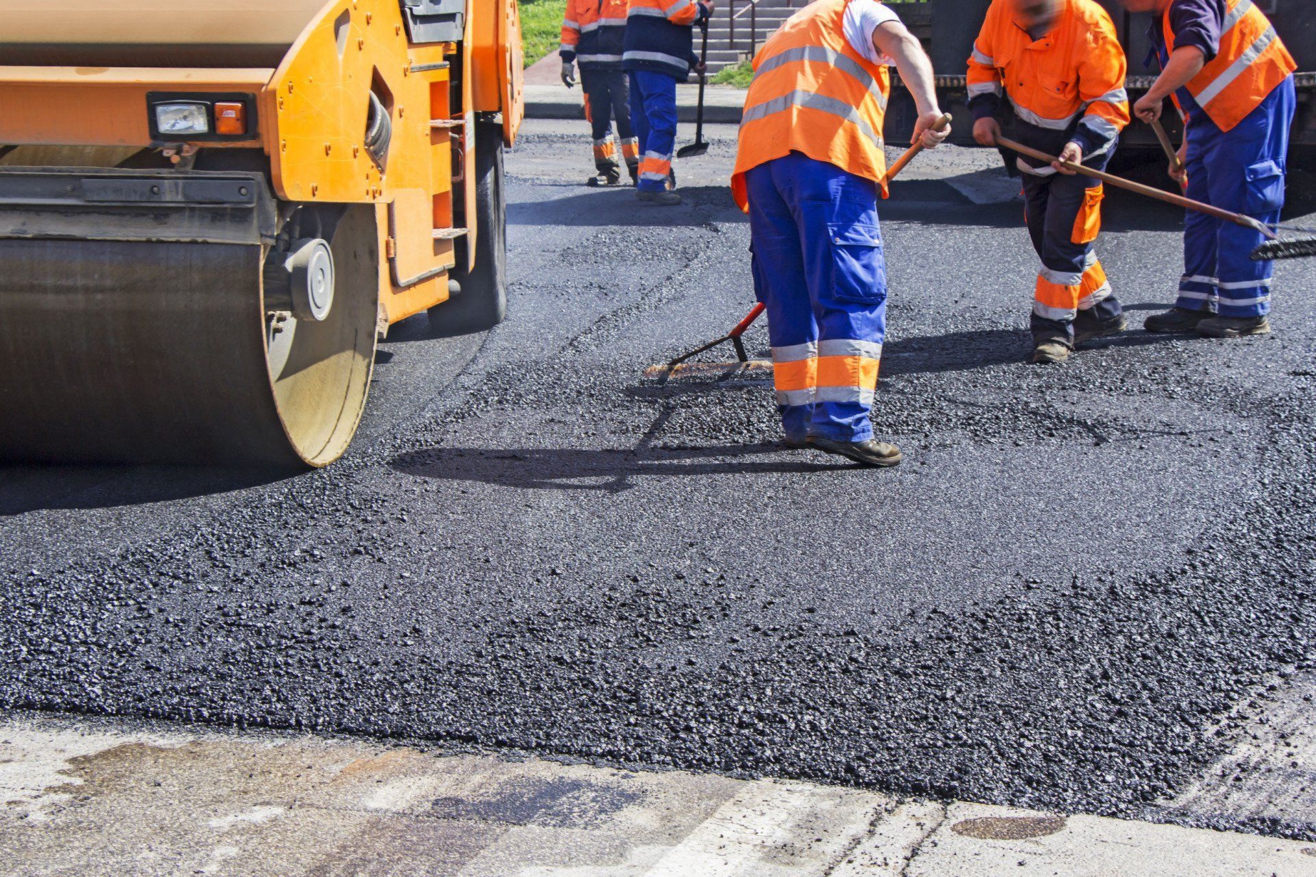 A group of construction workers are working on a road.