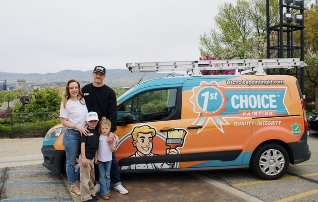 Family standing beside an orange 1st Choice service van with ladders on top in a parking lot