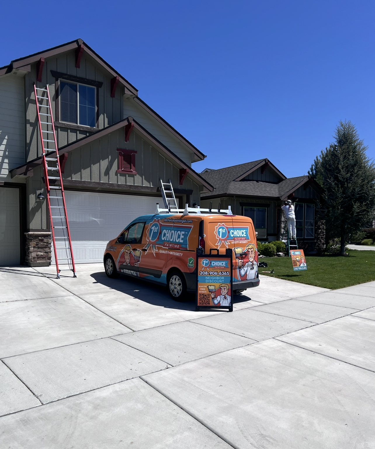 Orange promotional van parked in driveway beside a house, with a ladder leaning against the exterior.