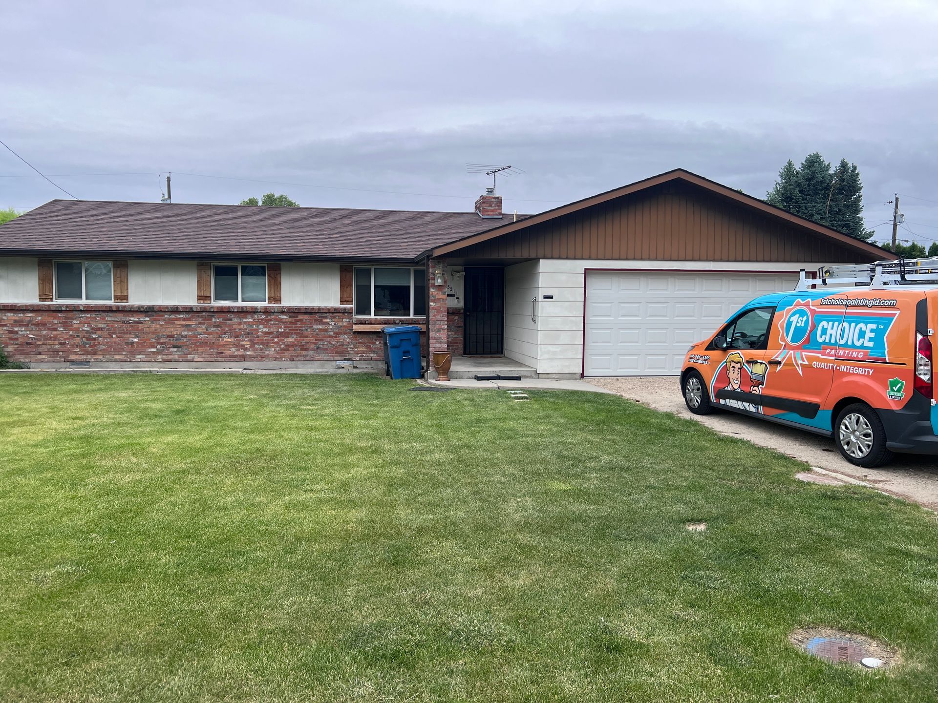 Single-story brick house with a white garage and an orange service van in the driveway.