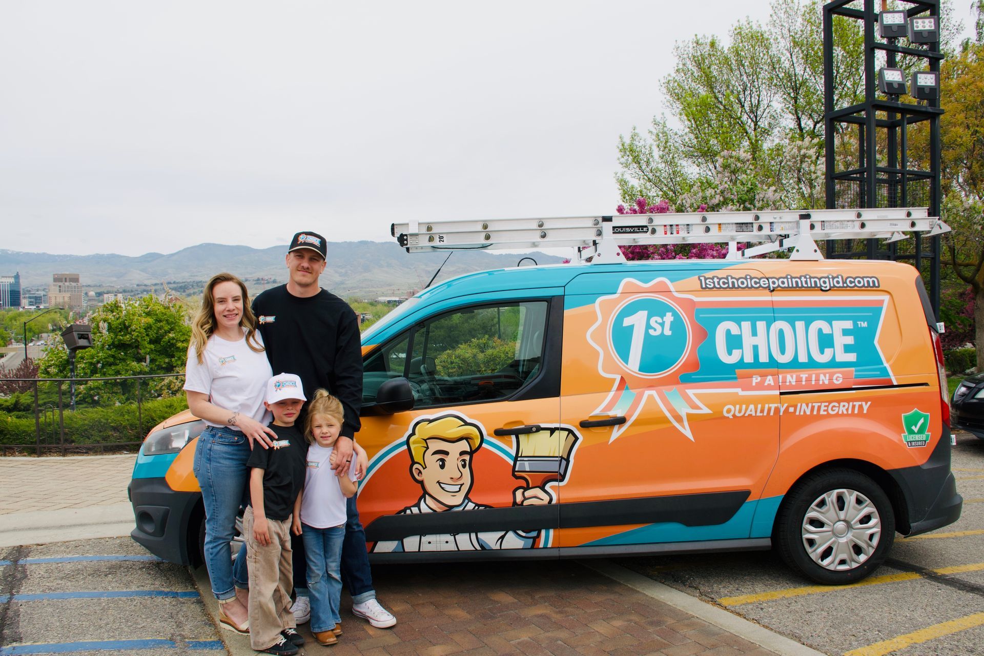 Family posing beside orange 1st Choice van on a roadside with a colorful logo