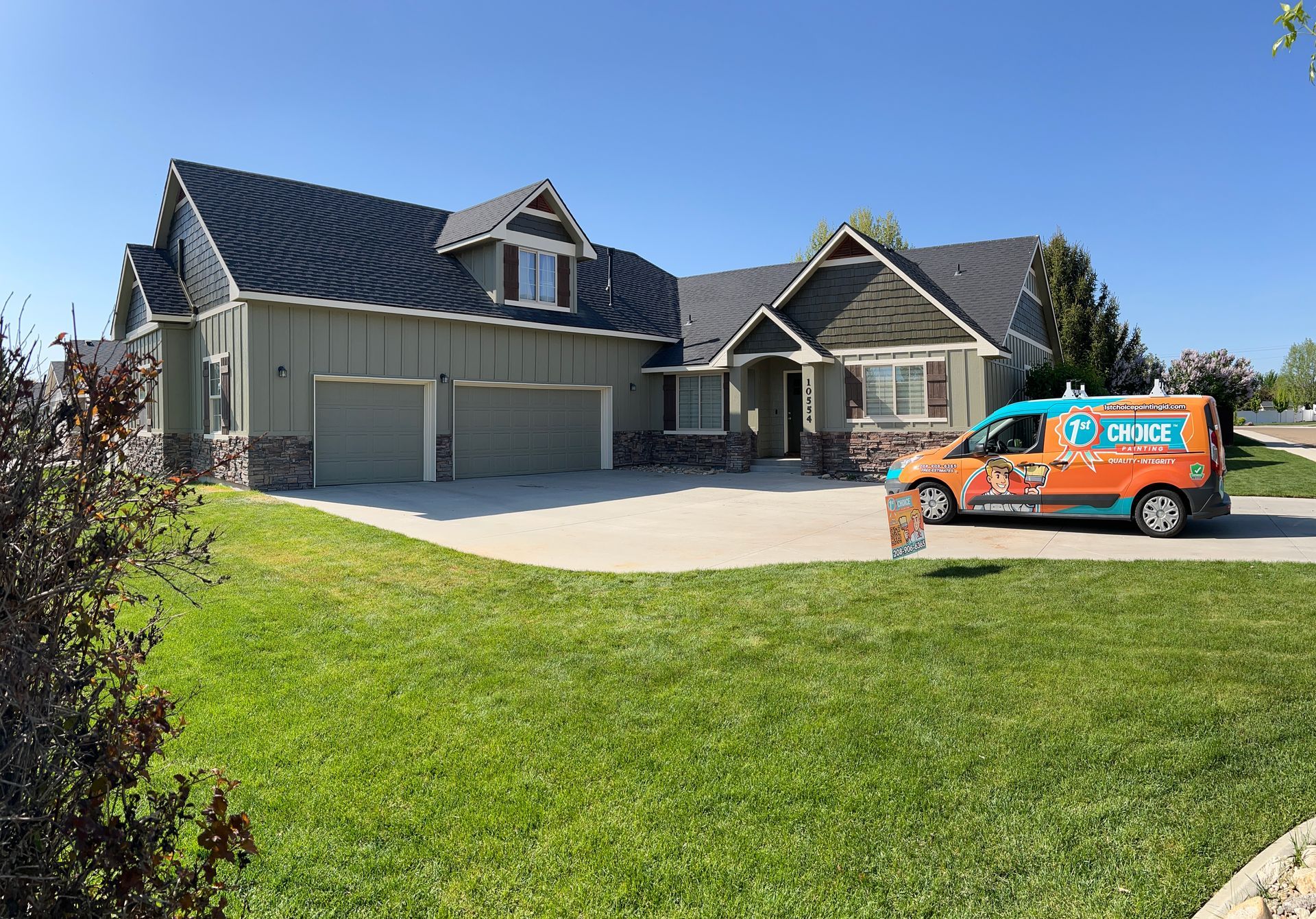 Suburban house with a two-car garage, green lawn, and an orange service van in the driveway.