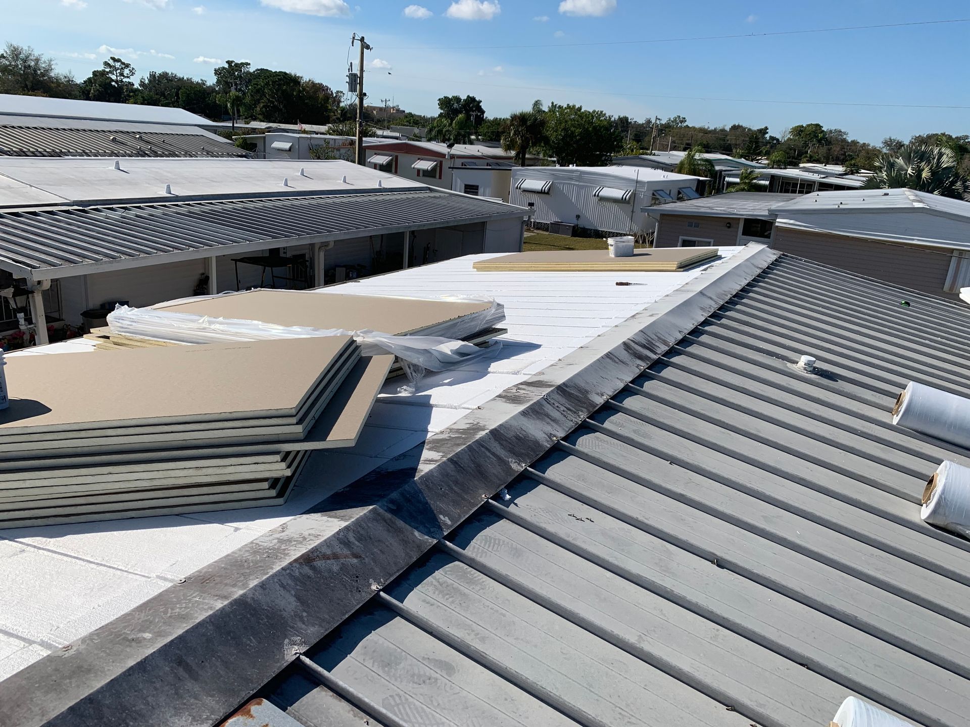 Rooftop with gray metal panels and HVAC units under a clear blue sky
