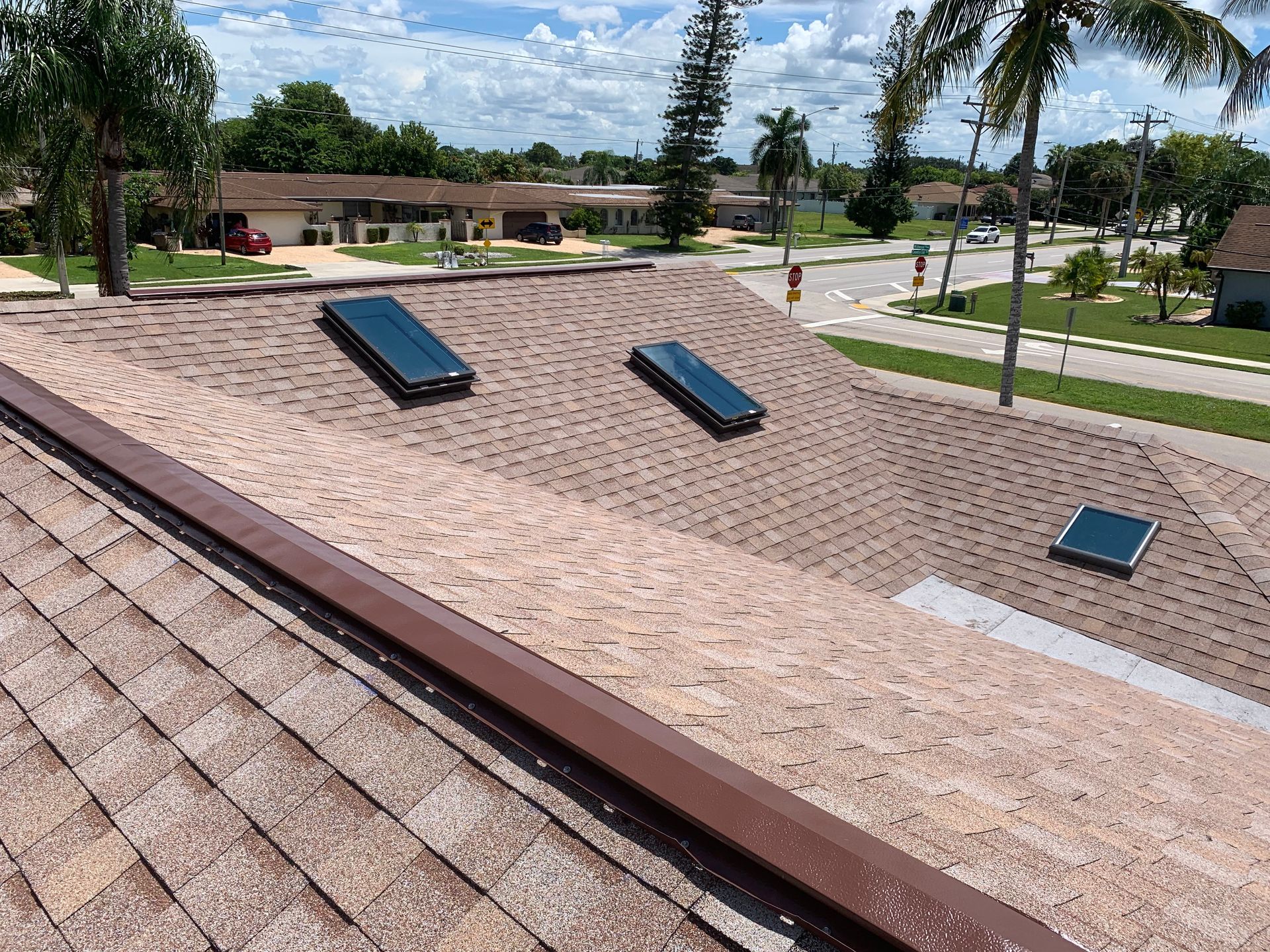 Angled rooftop with three skylights in a landscaped park on a sunny day