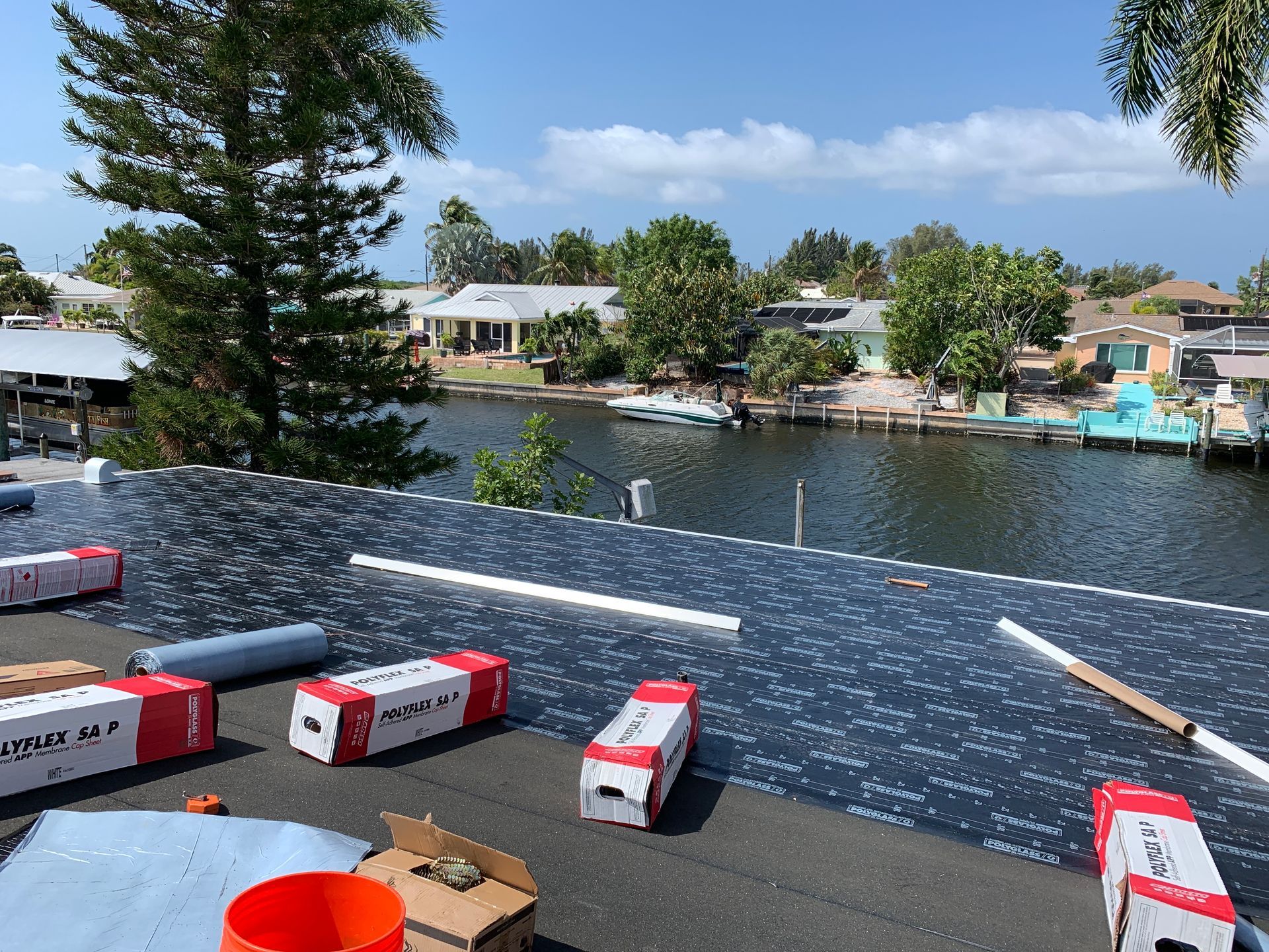 Rooftop with solar panels overlooking a calm canal and houses on a sunny day