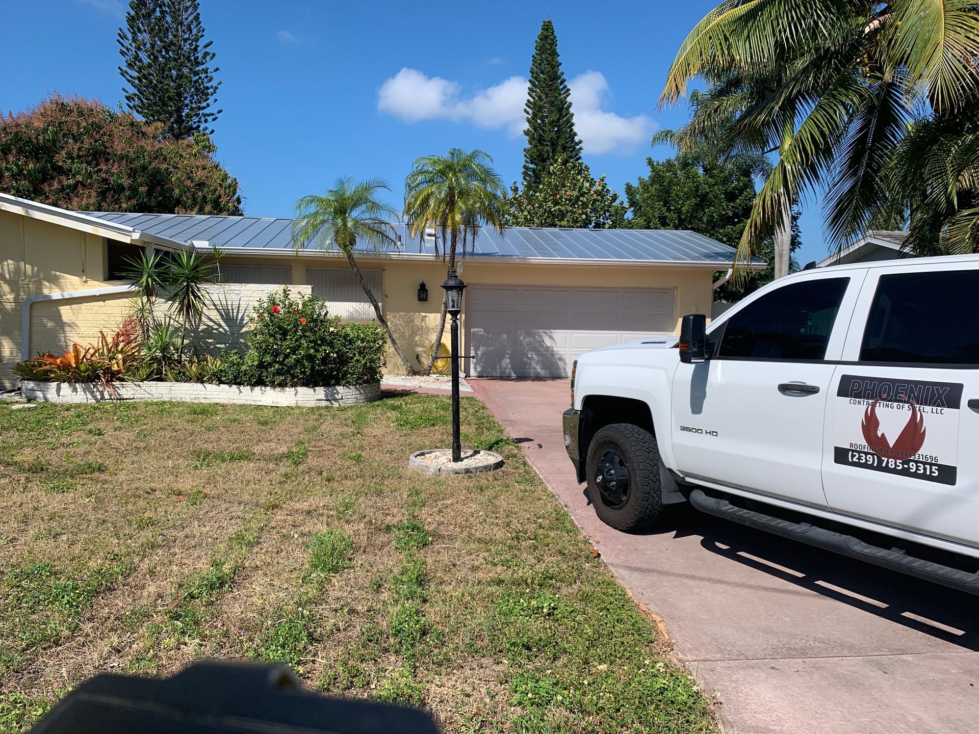 Suburban house with a white truck parked in the driveway and a front yard under a clear blue sky