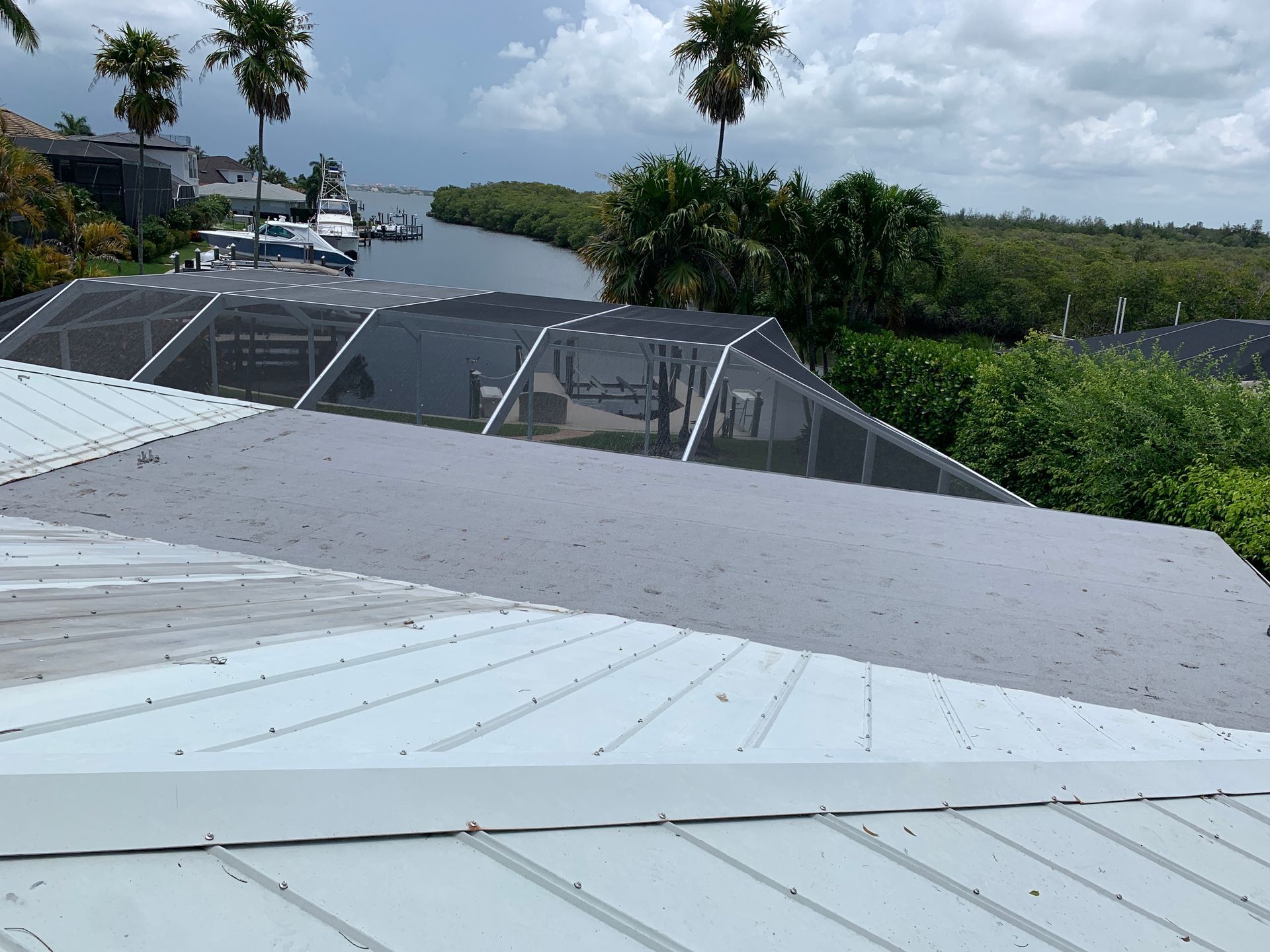 Rooftop view of a river, trees, and houses under a cloudy sky