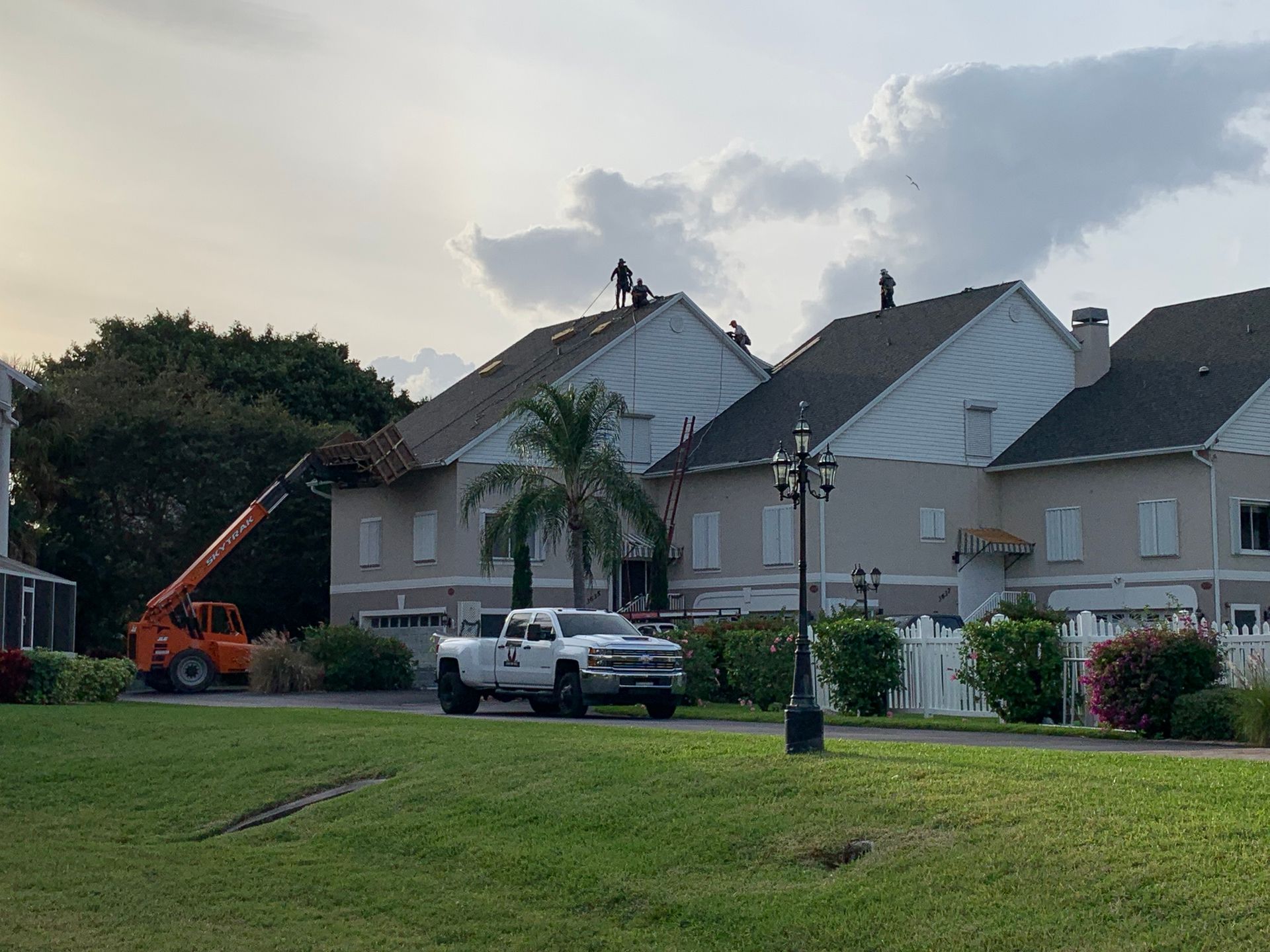 Residential houses under construction with a worker on the roof and a crane on the left