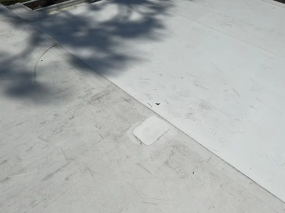 Concrete pavement with a small patch and tree shadows cast across it